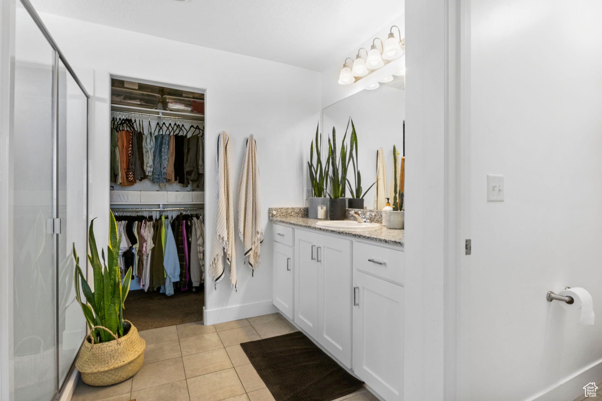 Bathroom with walk in shower, tile patterned flooring, and vanity