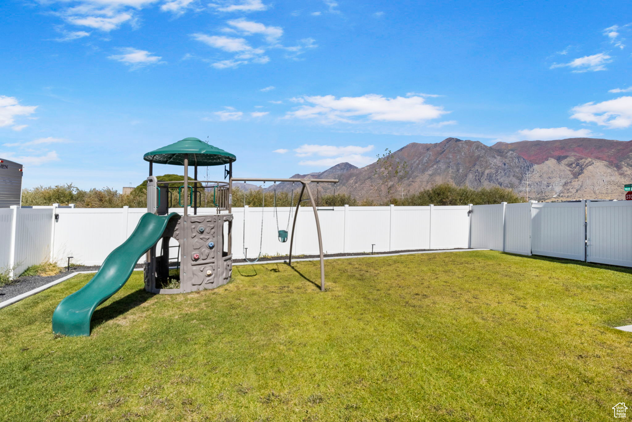 View of play area with a mountain view and a yard