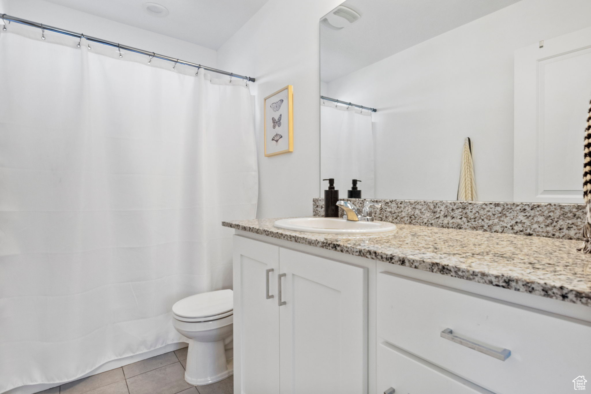 Bathroom featuring tile patterned floors, vanity, and toilet