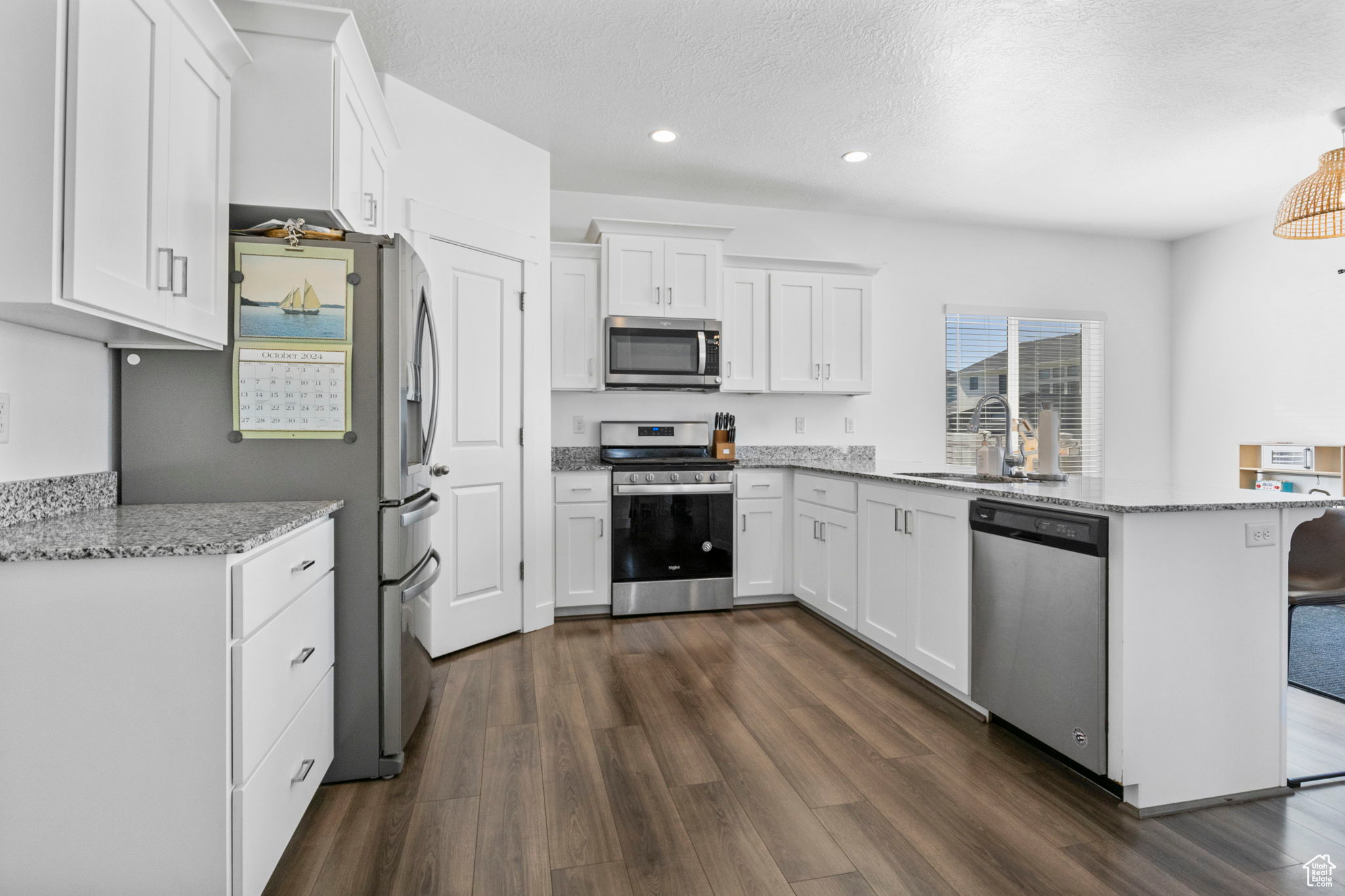 Kitchen featuring white cabinetry, appliances with stainless steel finishes, dark hardwood / wood-style floors, and sink