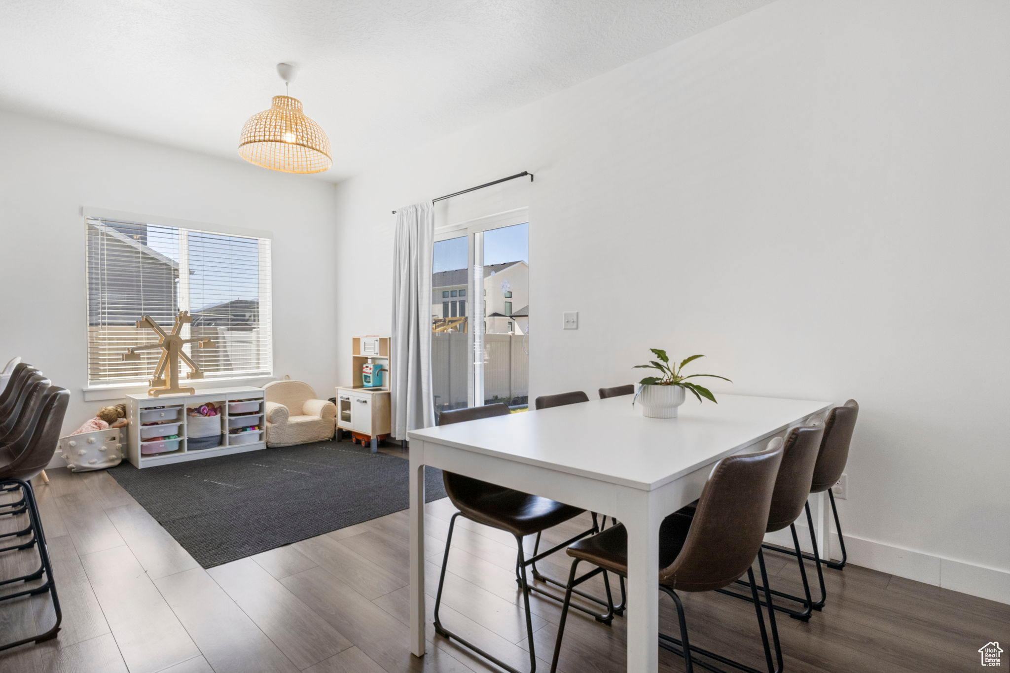 Dining space with dark wood-type flooring and a healthy amount of sunlight