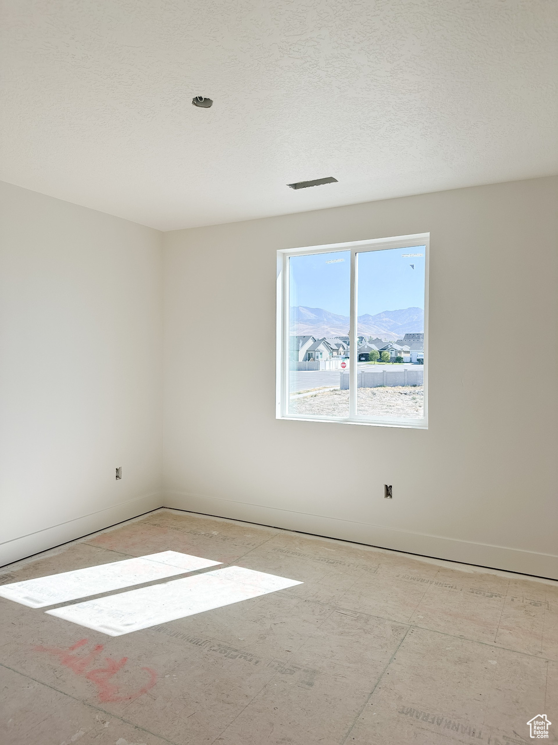 Unfurnished room featuring a mountain view and a textured ceiling