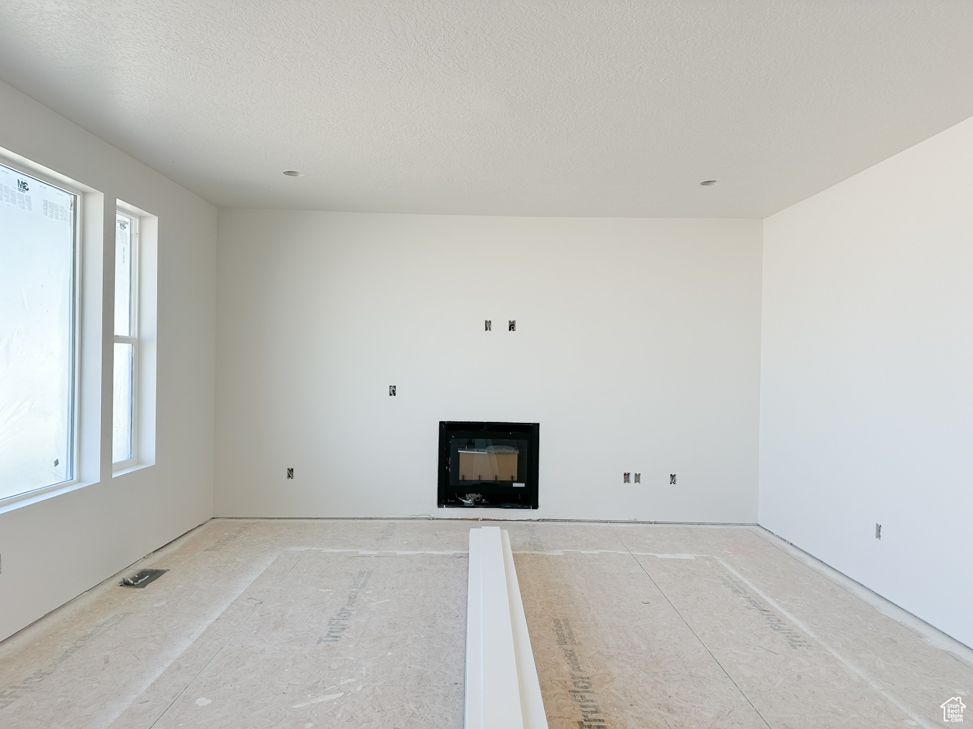 Unfurnished living room featuring a textured ceiling