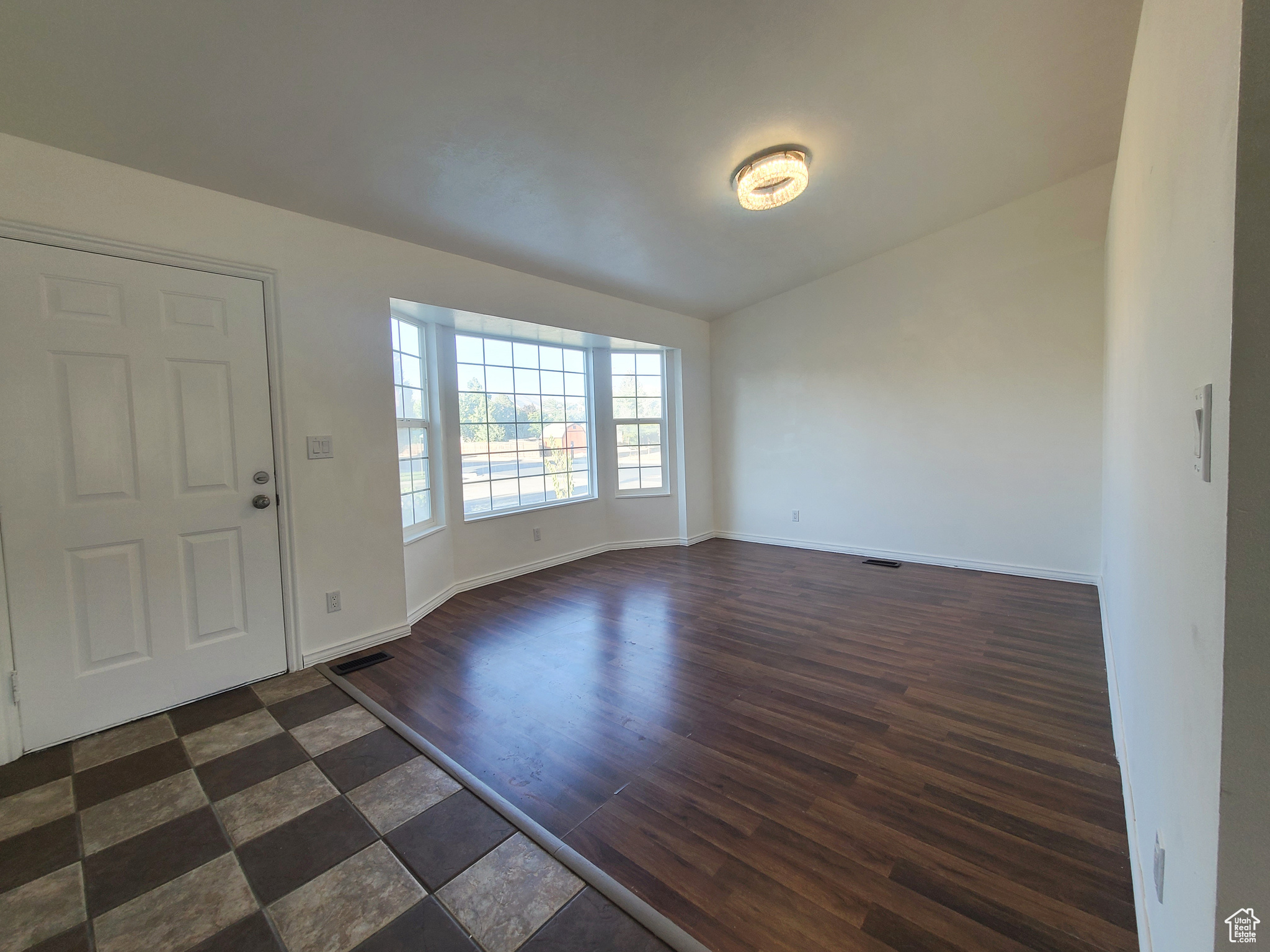 Entrance foyer featuring vaulted ceiling and laminate wood flooring