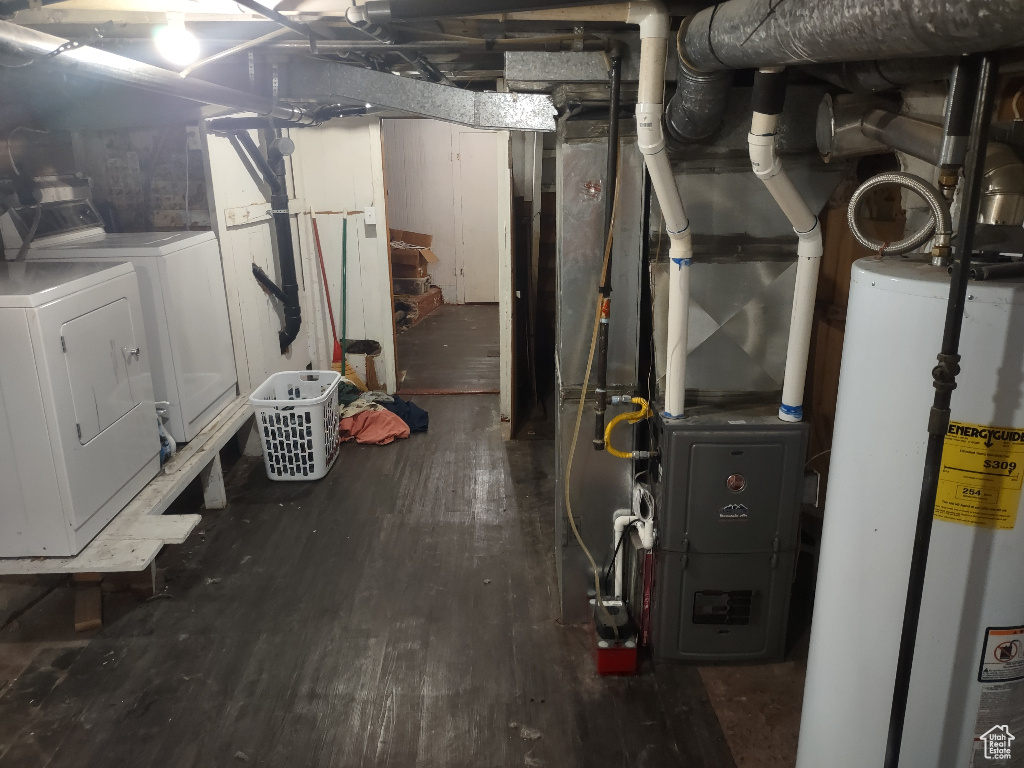 Basement with hardwood / wood-style flooring, water heater, and washer and dryer