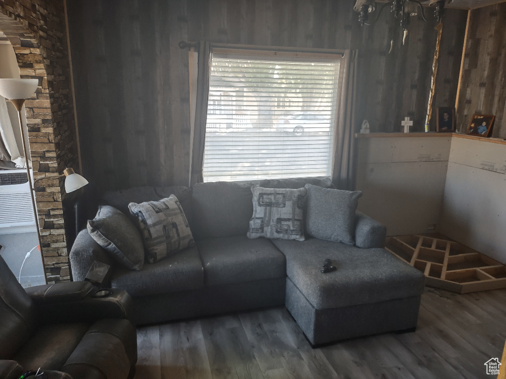 Living room with wooden walls and hardwood / wood-style flooring