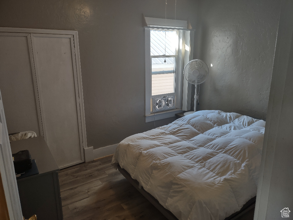 Bedroom with a closet and dark hardwood / wood-style floors