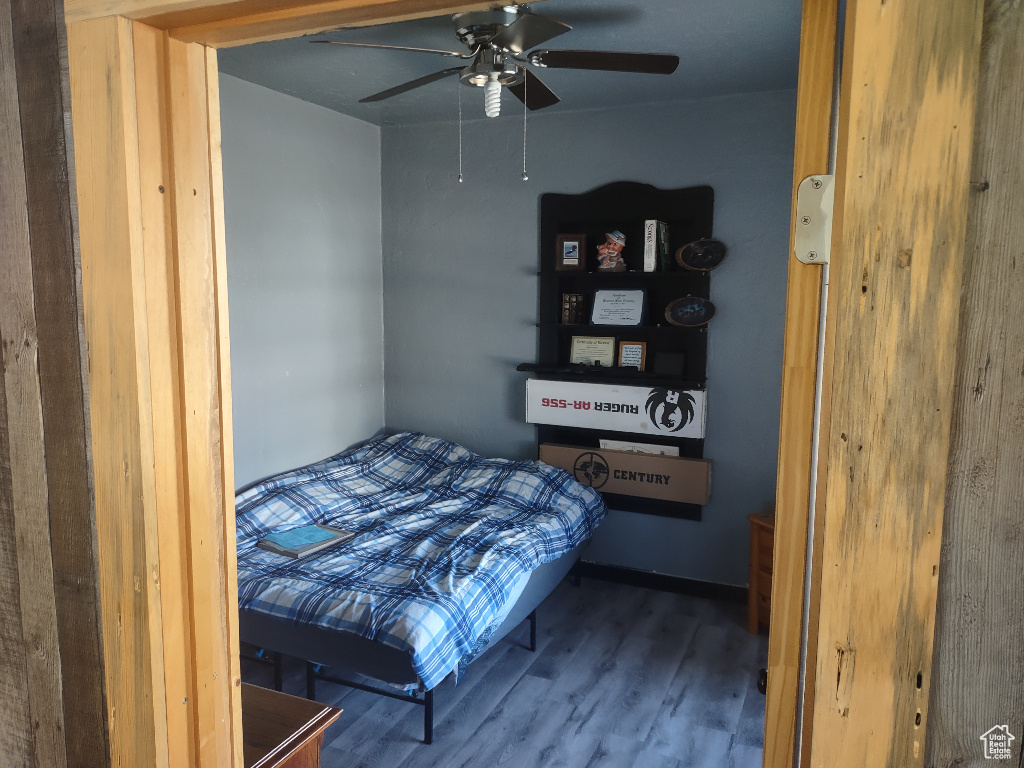 Bedroom with ceiling fan and hardwood / wood-style flooring