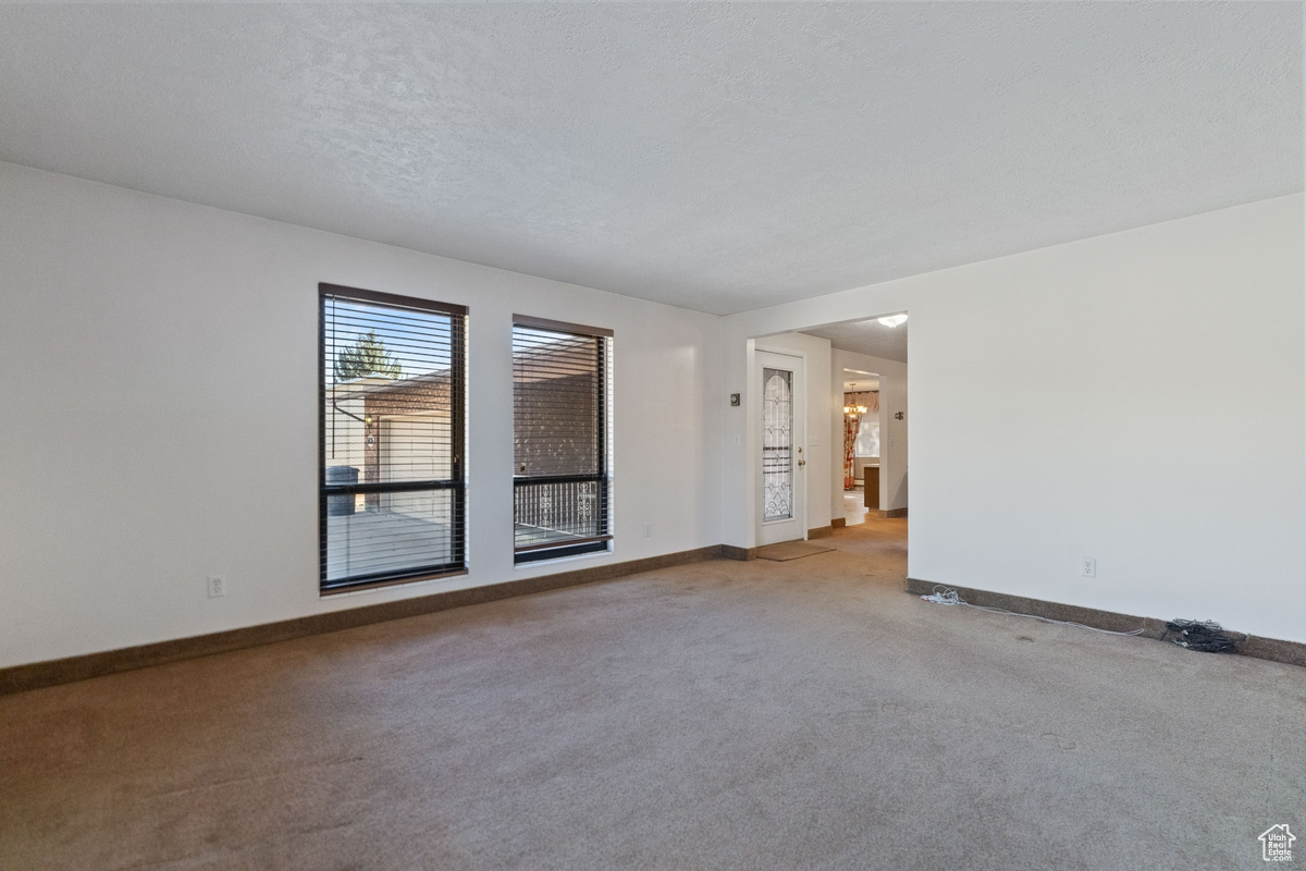 Spare room featuring a textured ceiling and carpet flooring