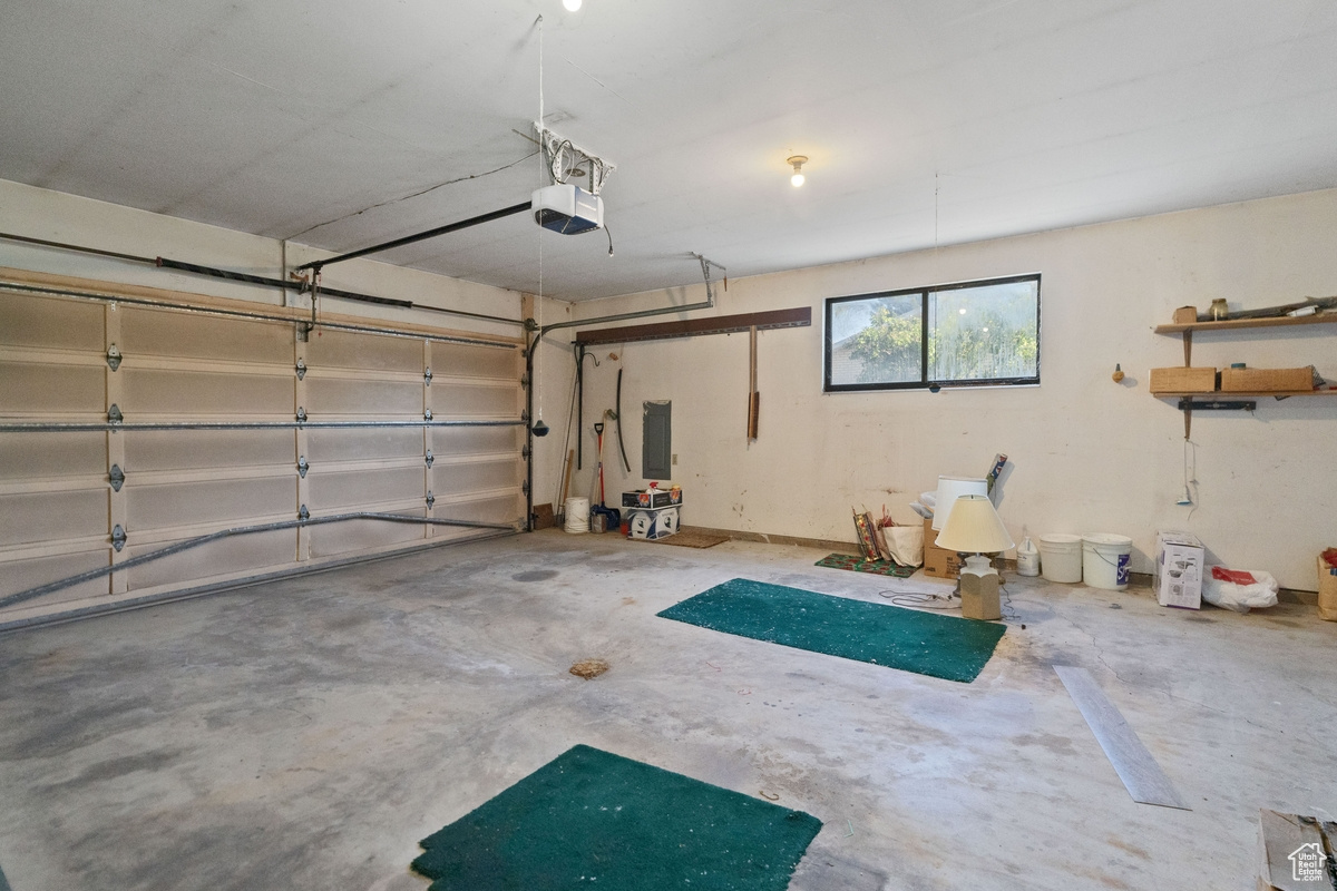 Garage featuring a garage door opener and electric panel