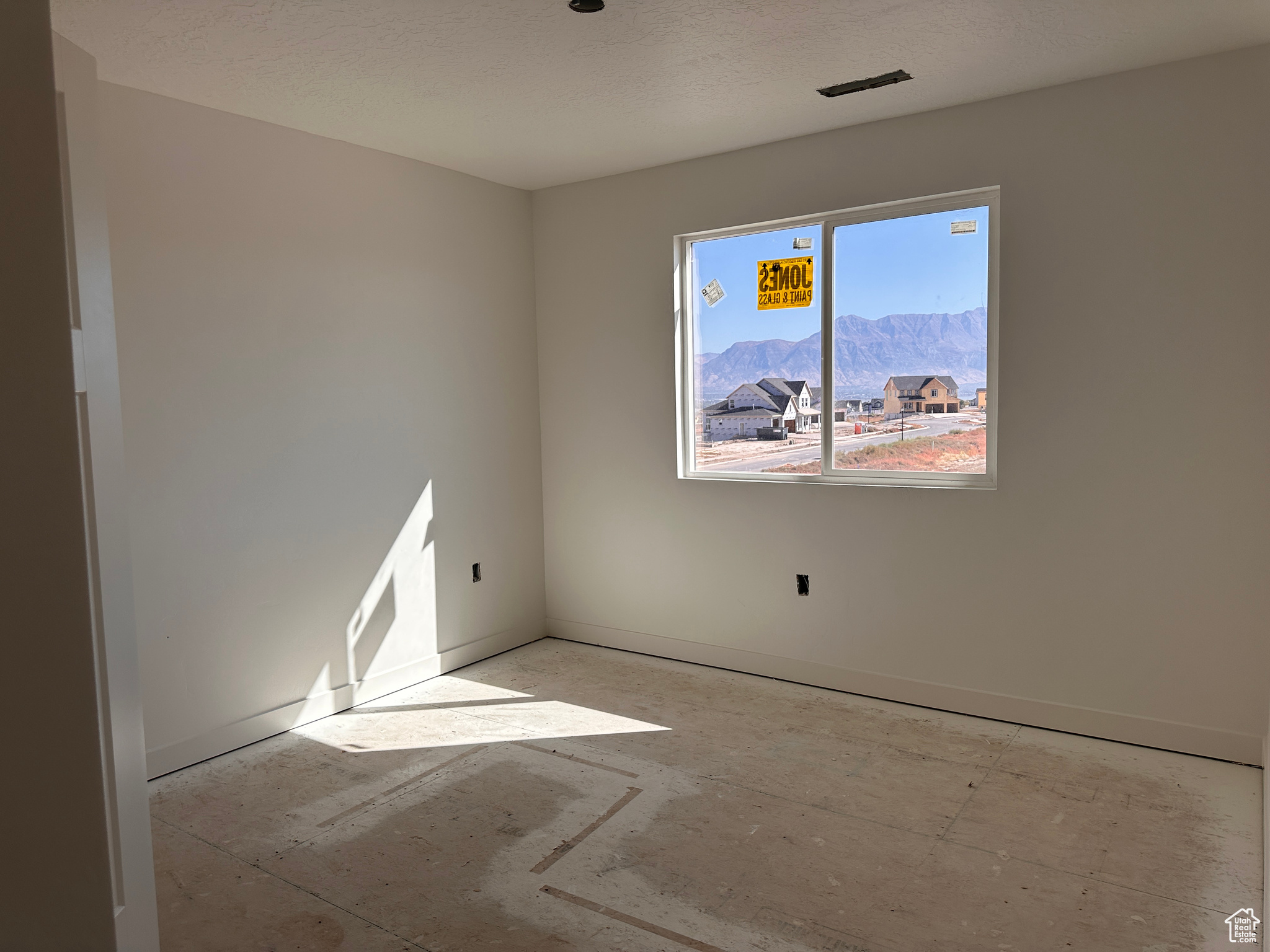 Spare room with a mountain view and a textured ceiling