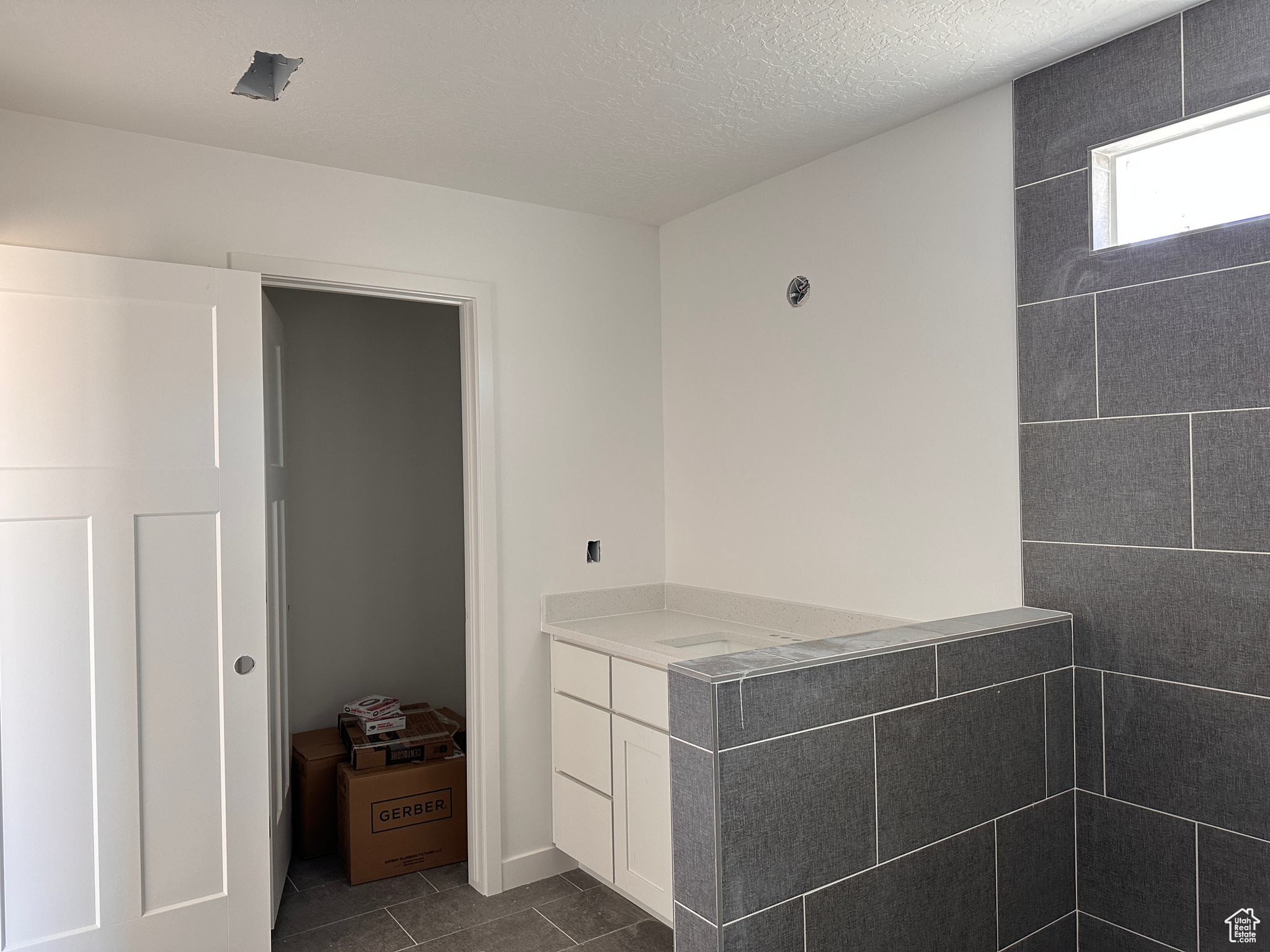 Bathroom featuring tile patterned flooring, a textured ceiling, and vanity