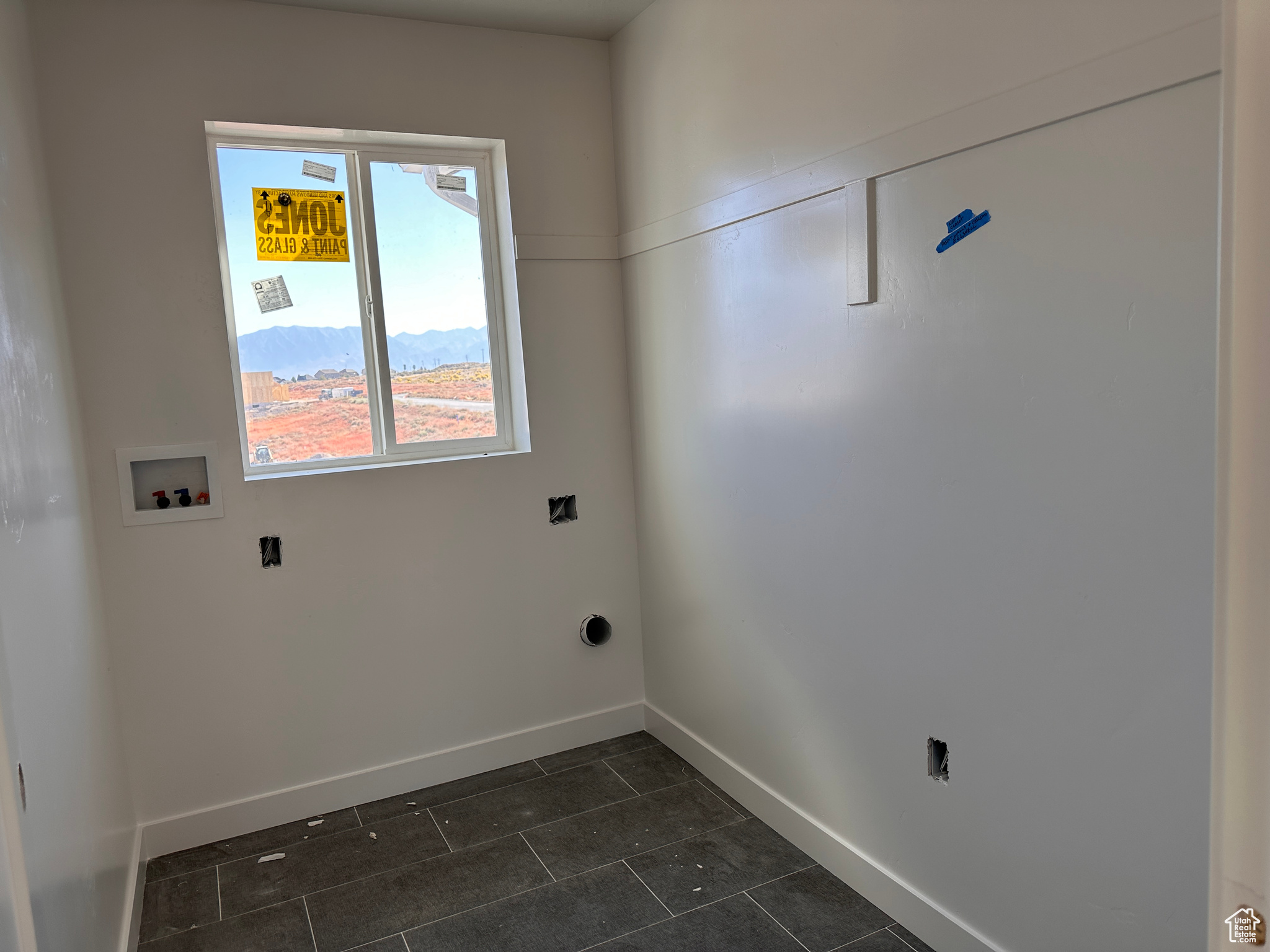 Laundry area with washer hookup, a mountain view, and dark tile patterned floors