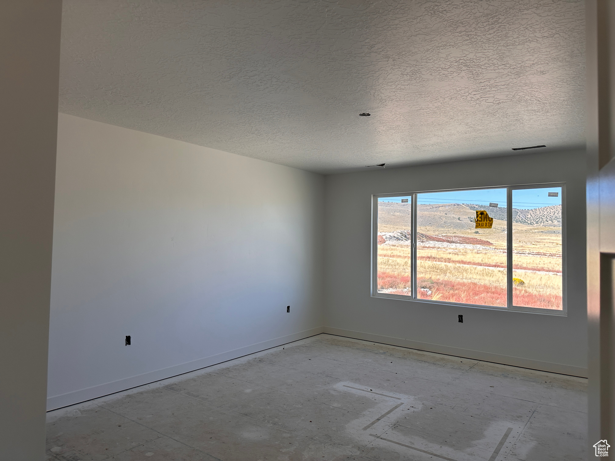 Empty room featuring a mountain view and a textured ceiling