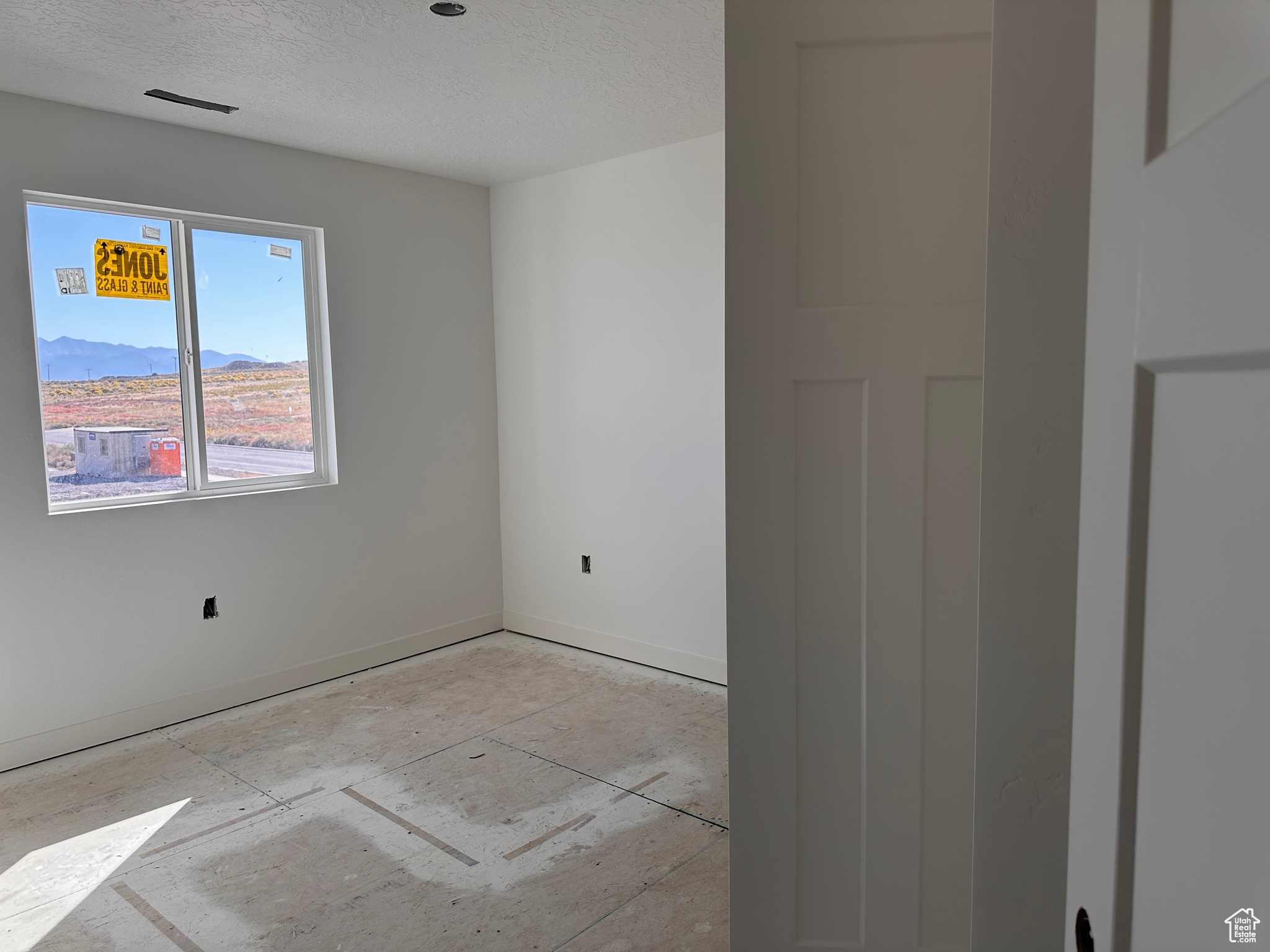 Unfurnished room featuring a mountain view and a textured ceiling