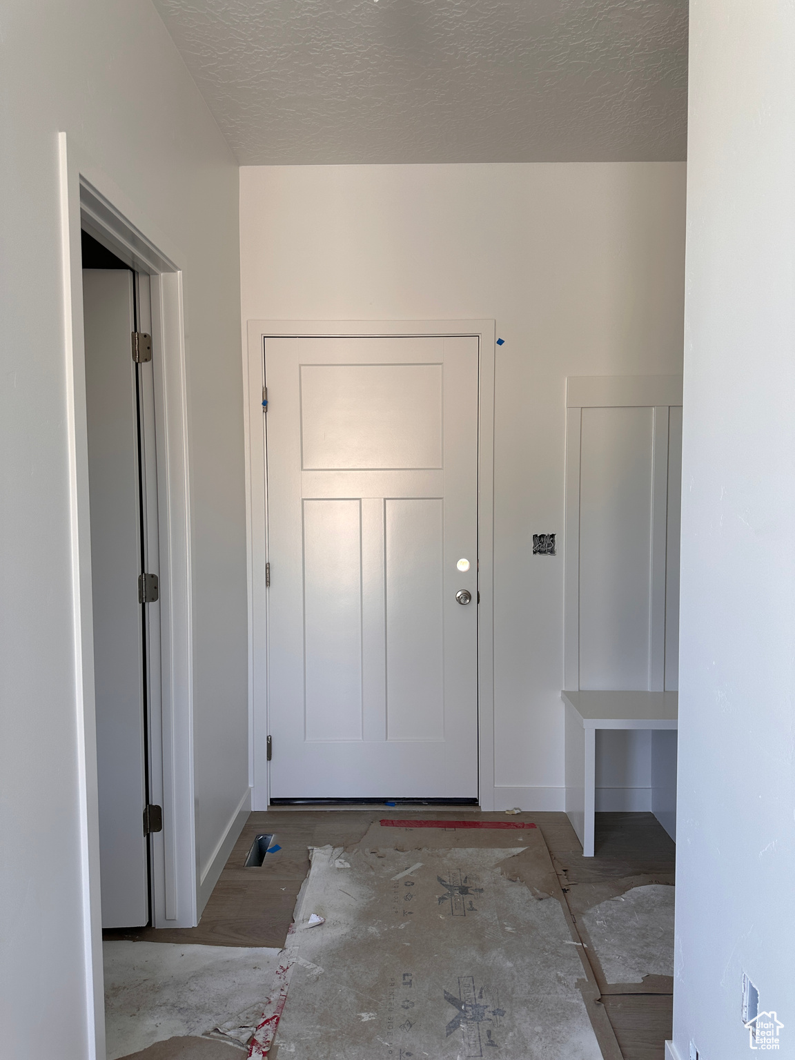 Doorway to outside featuring a textured ceiling