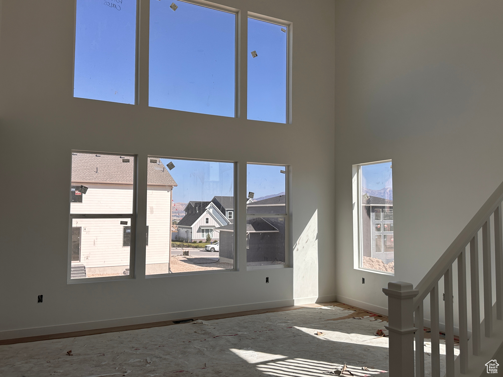 Unfurnished living room featuring a towering ceiling