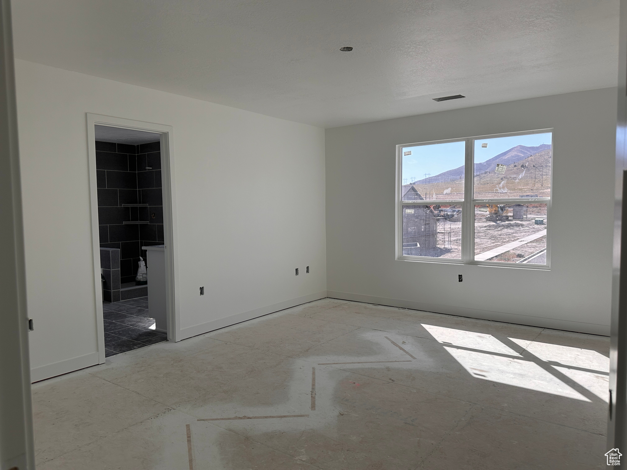 Empty room featuring a textured ceiling, a fireplace, and a mountain view