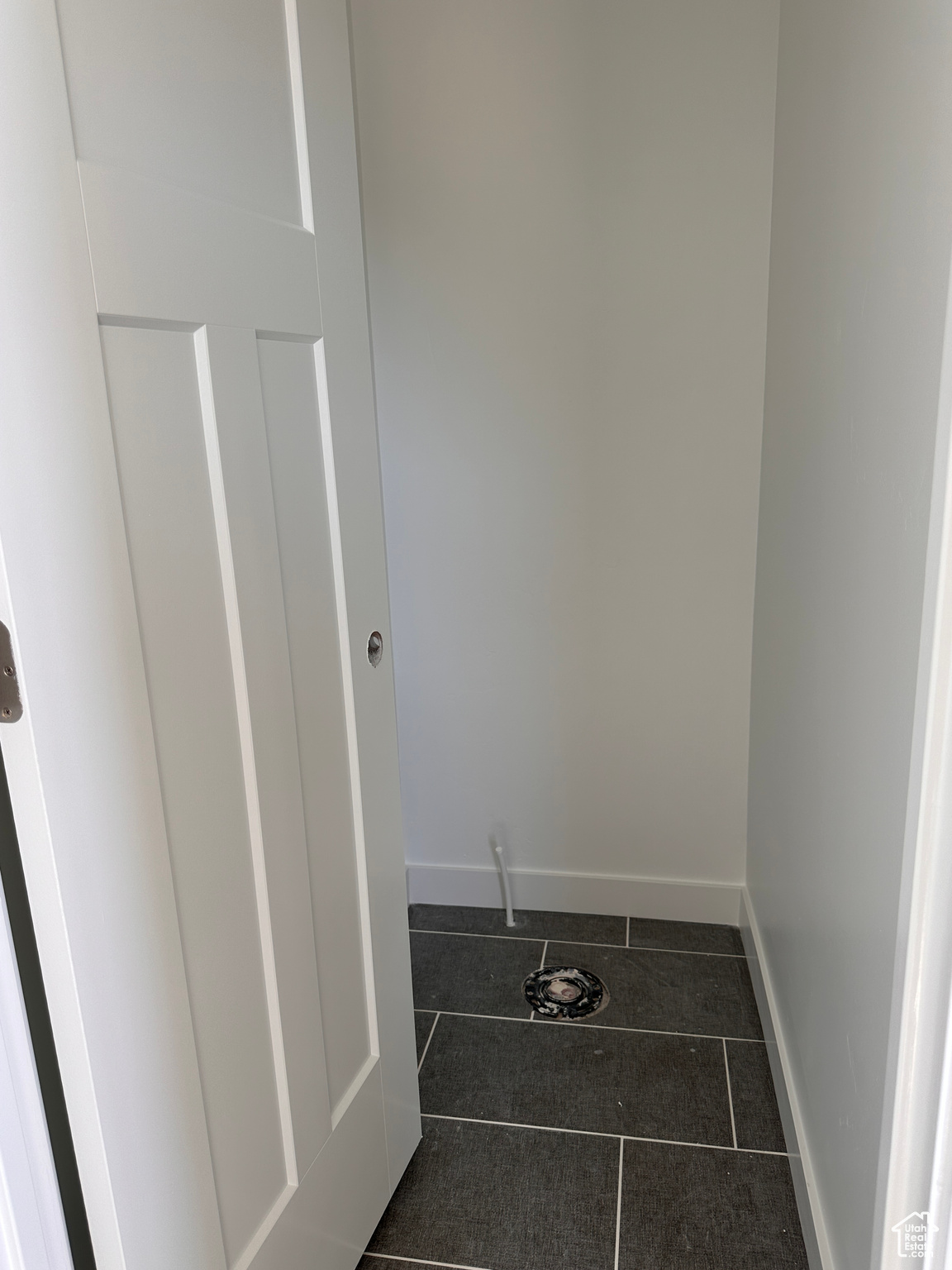 Laundry area with dark tile patterned flooring