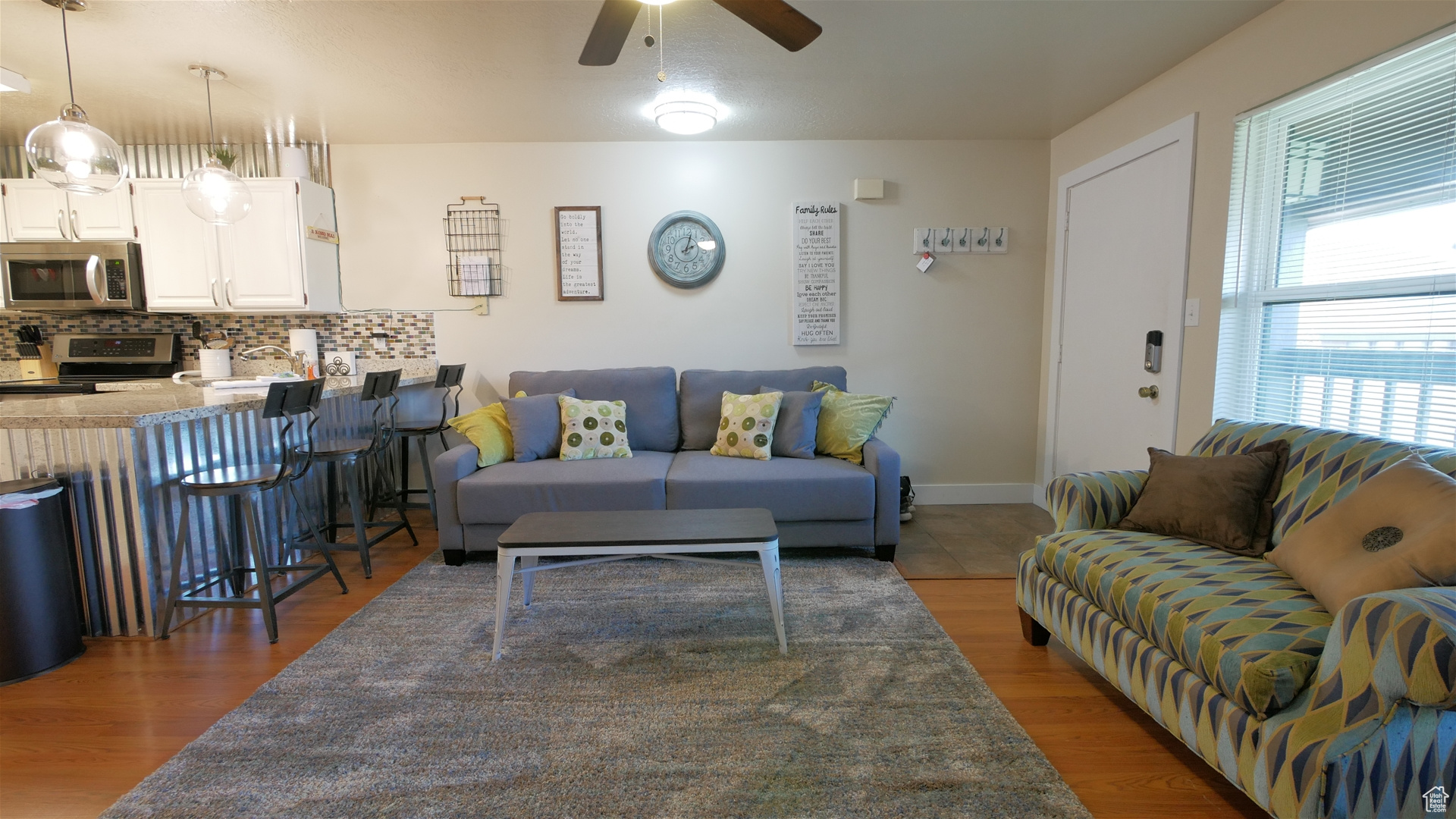 Living room with dark hardwood / wood-style floors and ceiling fan