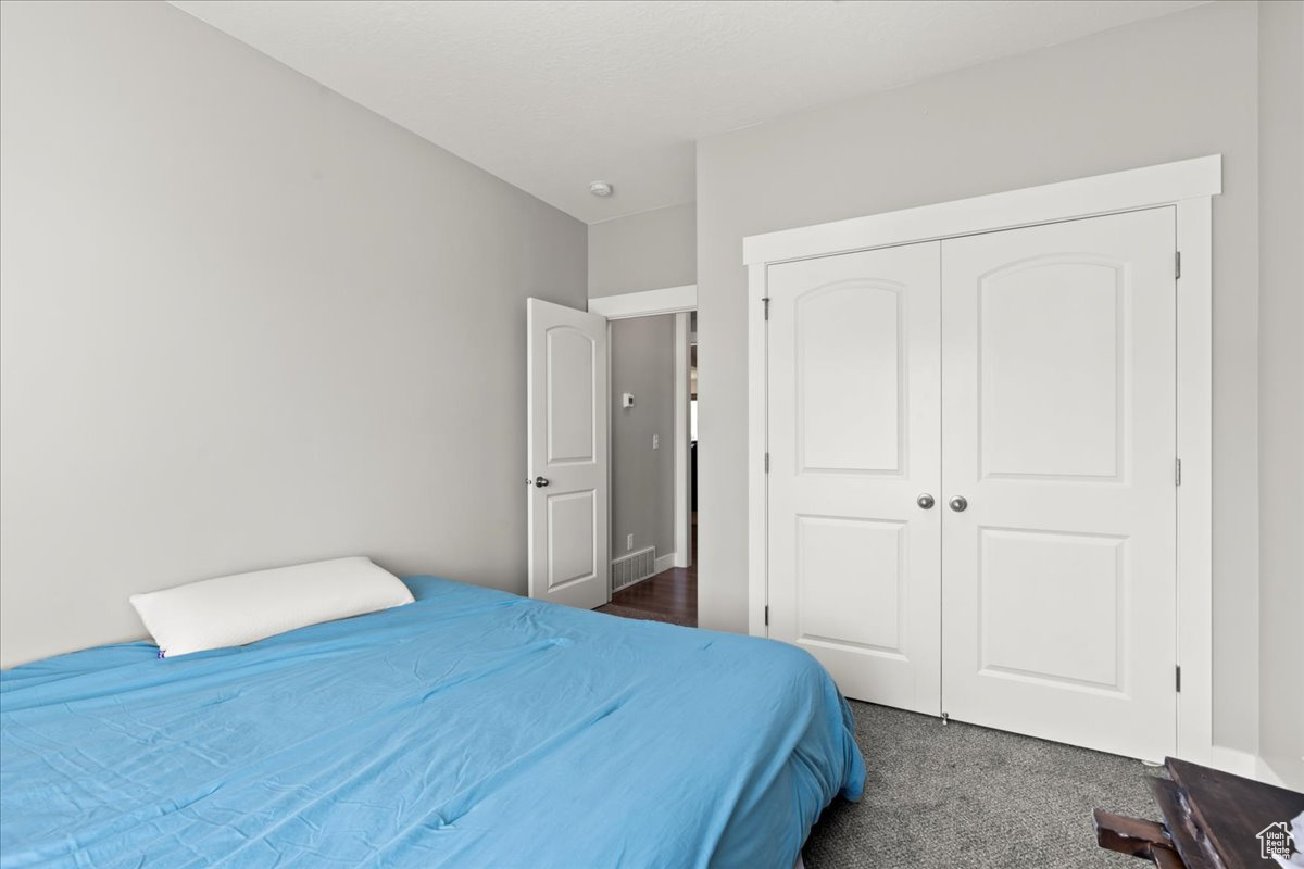 Carpeted bedroom featuring a closet