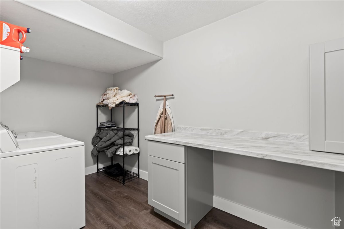 Interior space with washer and clothes dryer, cabinets, and dark hardwood / wood-style floors