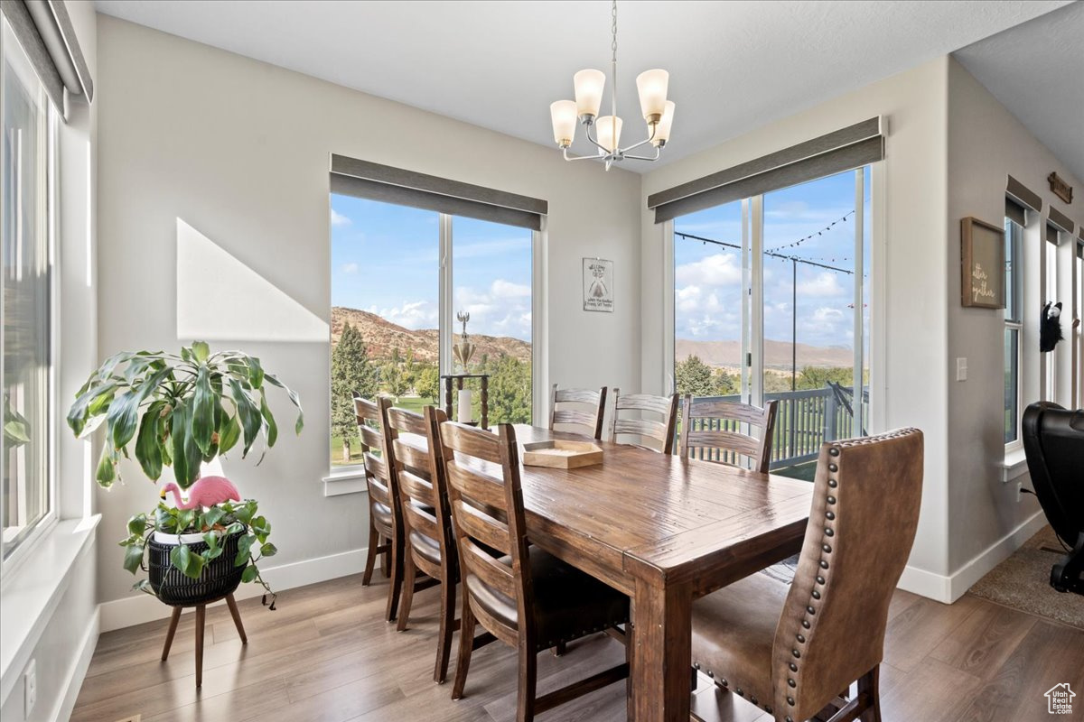 Dining room with a mountain view, an inviting chandelier, and hardwood / wood-style floors