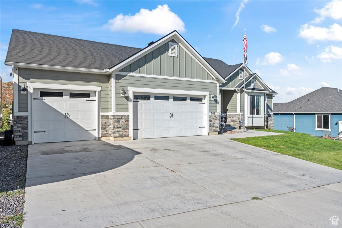 Craftsman inspired home featuring a front yard and a garage