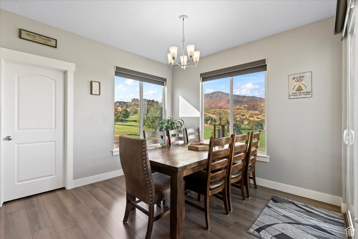 Dining space featuring an inviting chandelier, hardwood / wood-style floors, and a mountain view