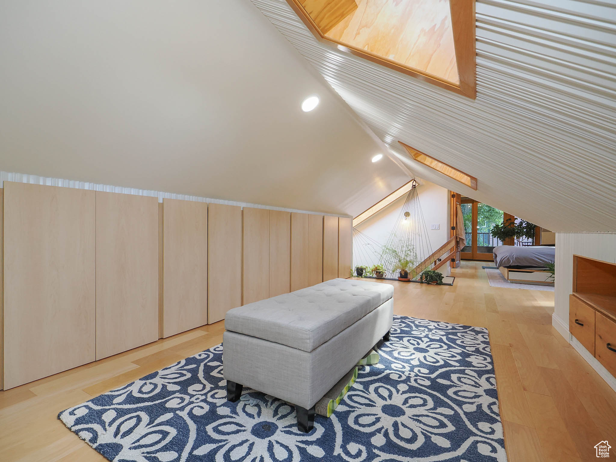 Bedroom with light wood-type flooring and lofted ceiling with skylight