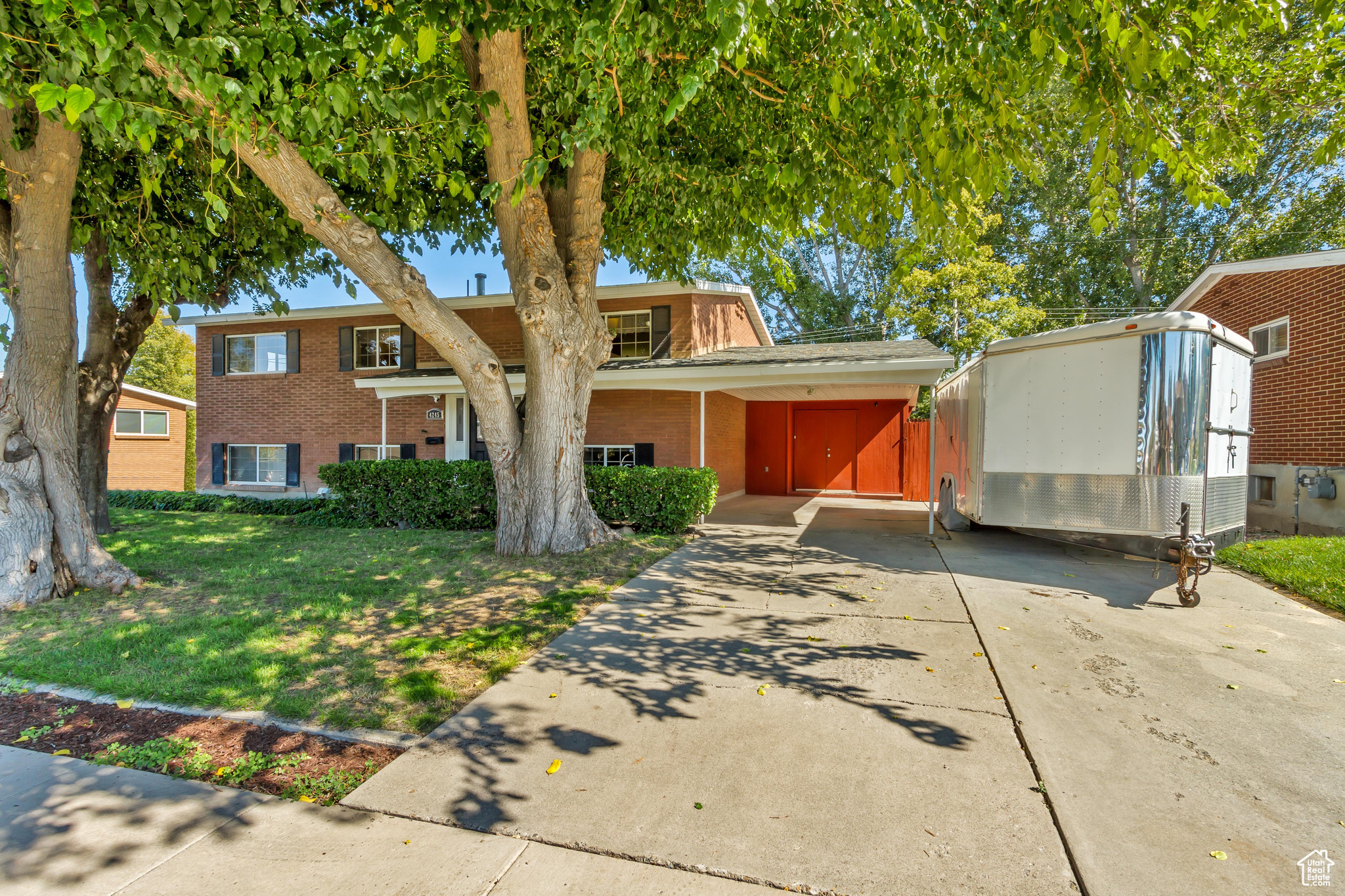 View of front of property featuring a front yard and a carport