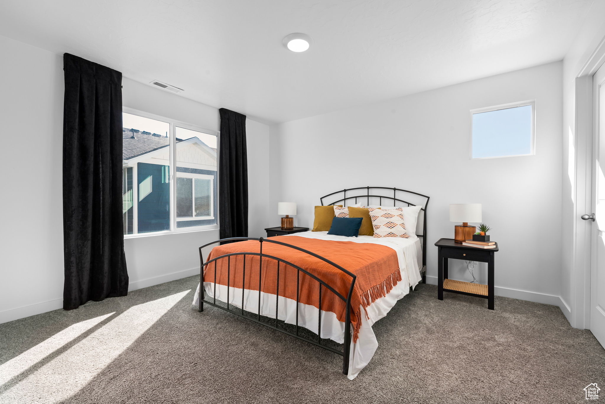 Bedroom featuring dark colored carpet and multiple windows