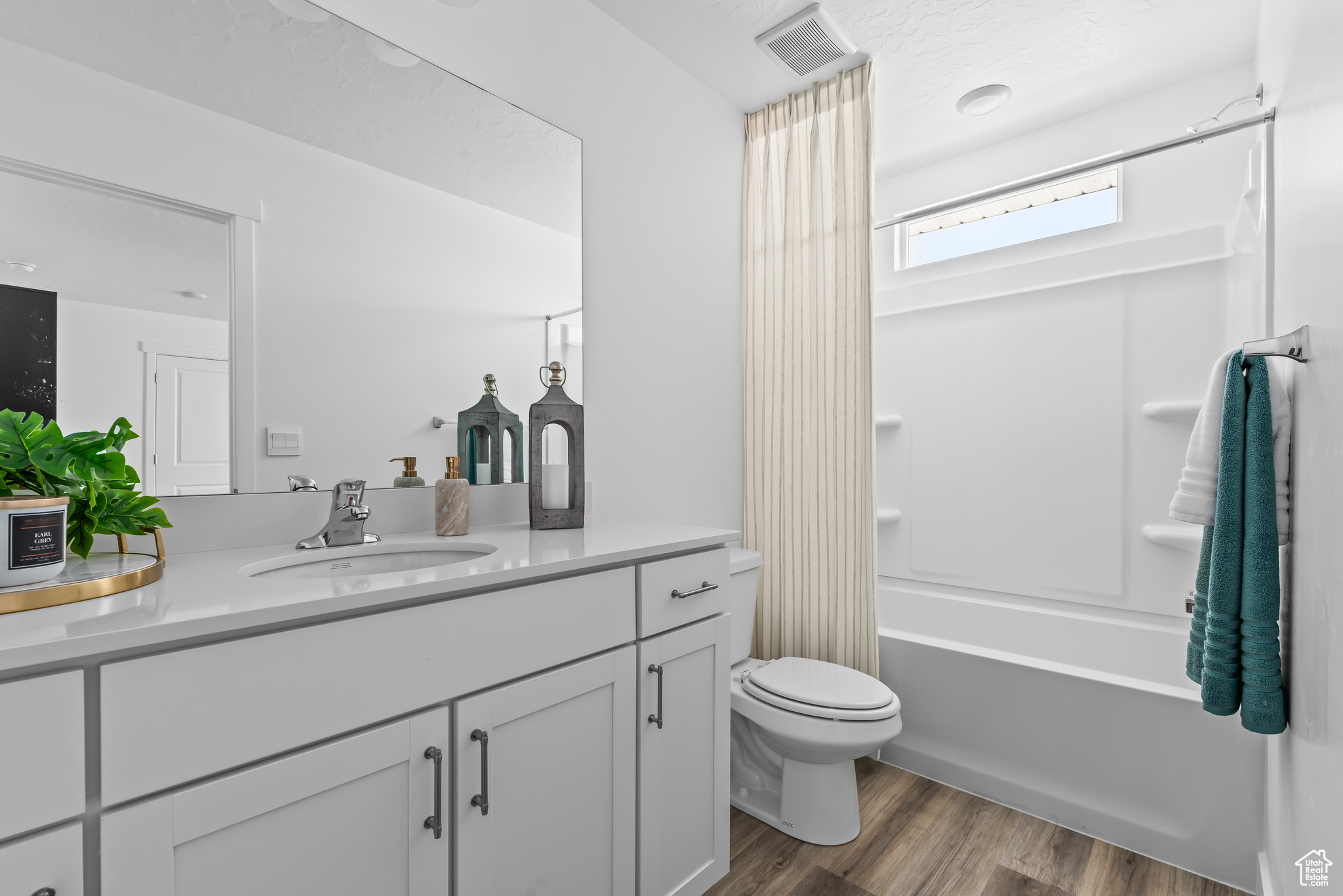 Full bathroom featuring wood-type flooring, shower / bath combination, vanity, and toilet