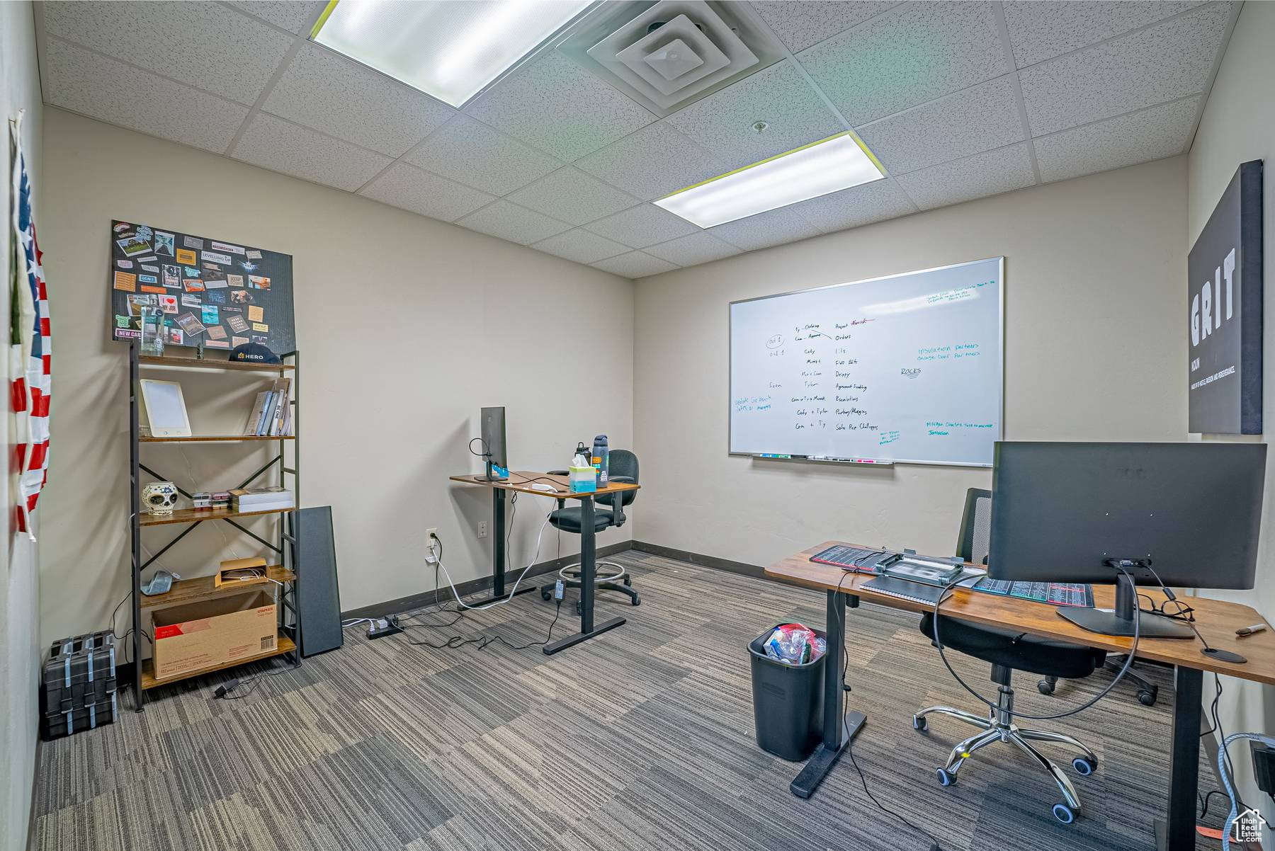 Carpeted office space featuring a paneled ceiling