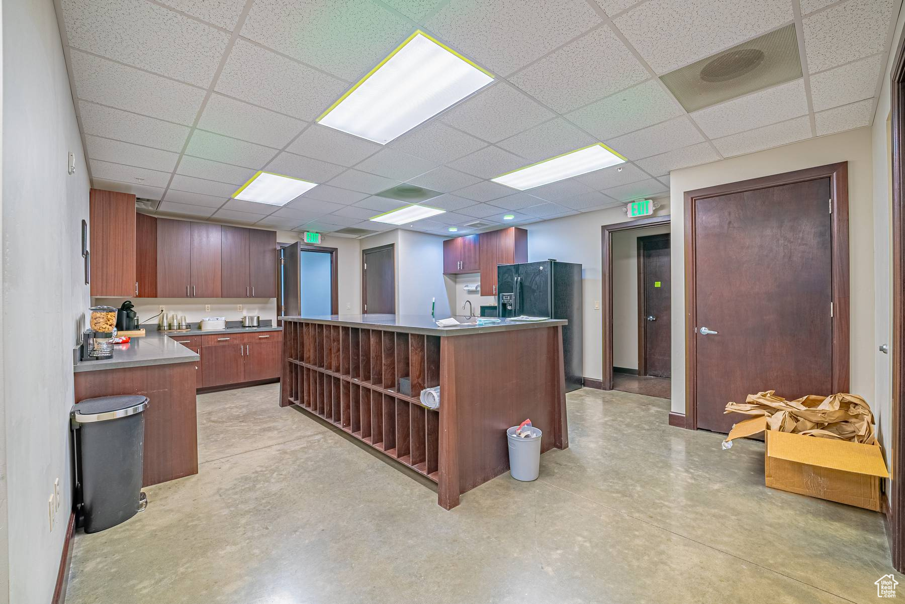 Kitchen featuring a drop ceiling, a kitchen island, and sink