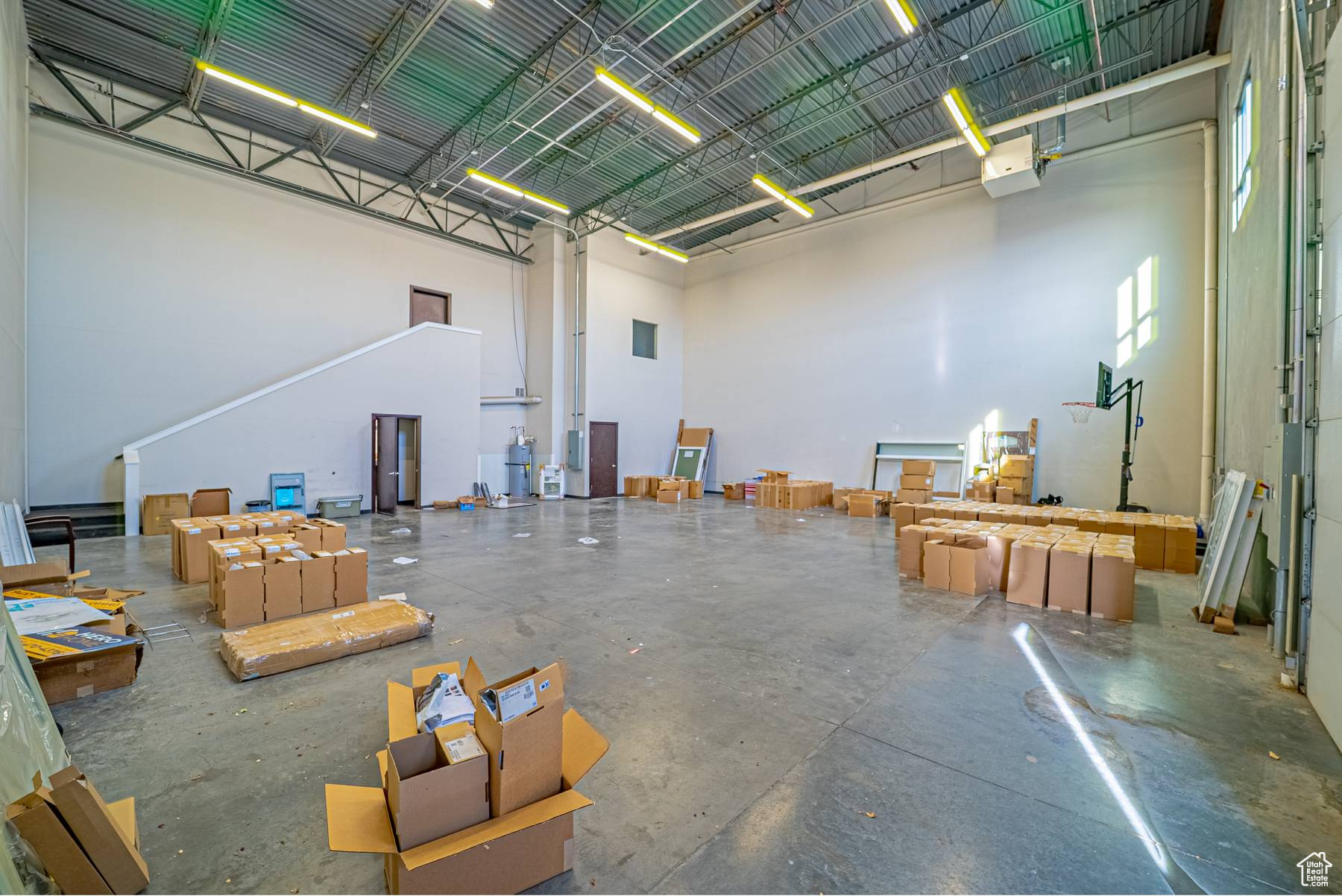 Misc room with a towering ceiling and concrete floors