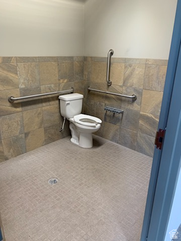 Bathroom featuring tile walls, tile patterned flooring, and toilet