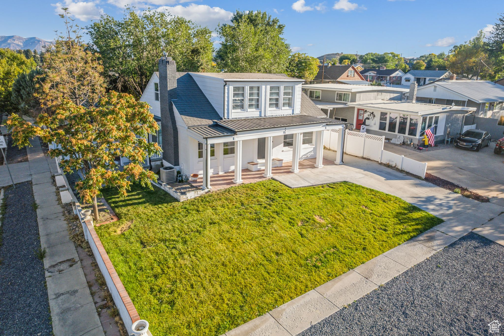 View of front facade featuring a front yard, a porch, and central AC