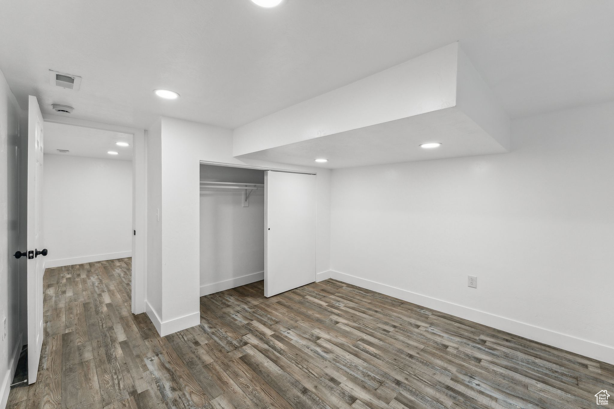 Unfurnished bedroom with dark wood-type flooring and a closet