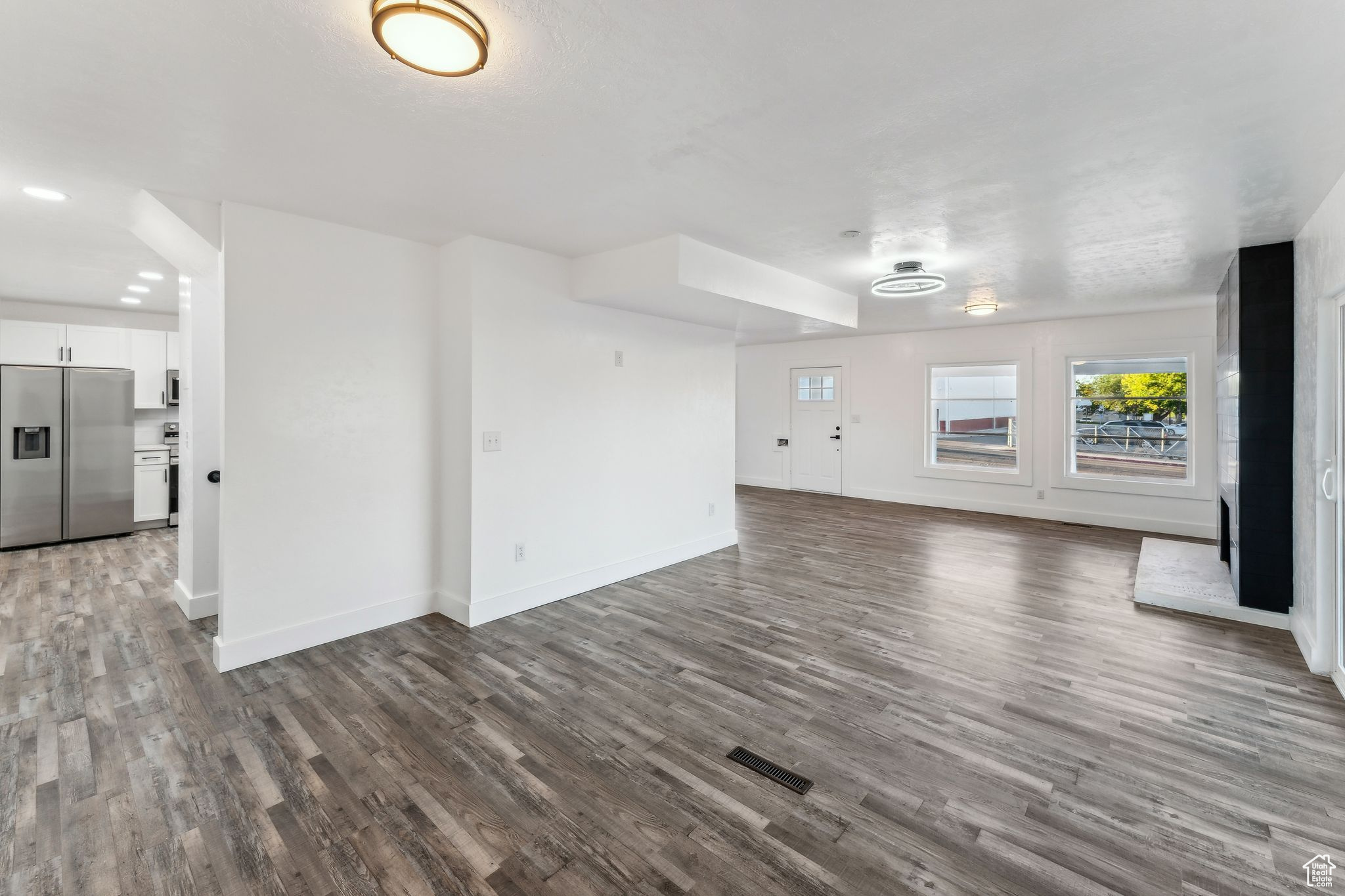 Unfurnished living room with dark wood-type flooring