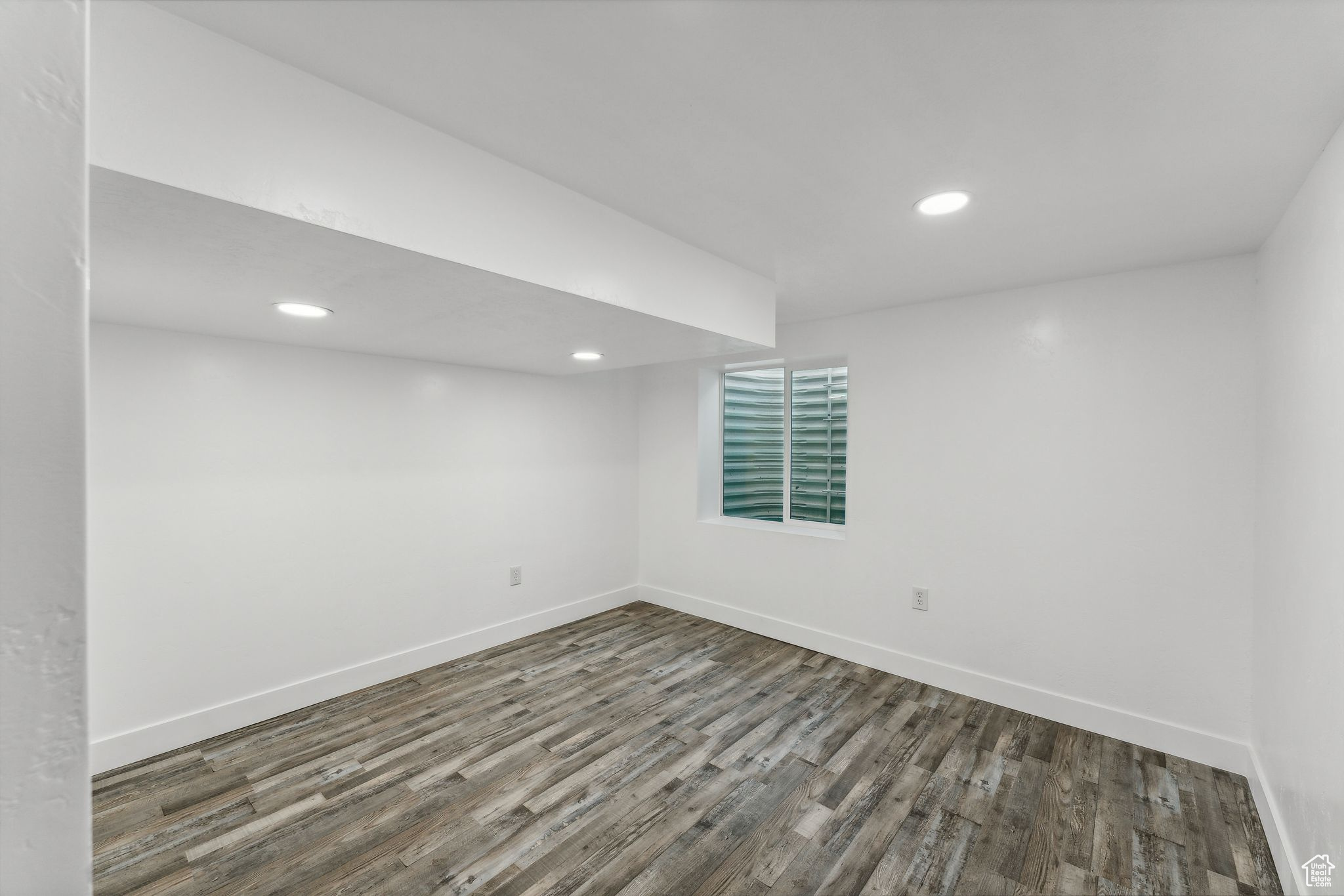 Basement with dark hardwood / wood-style flooring