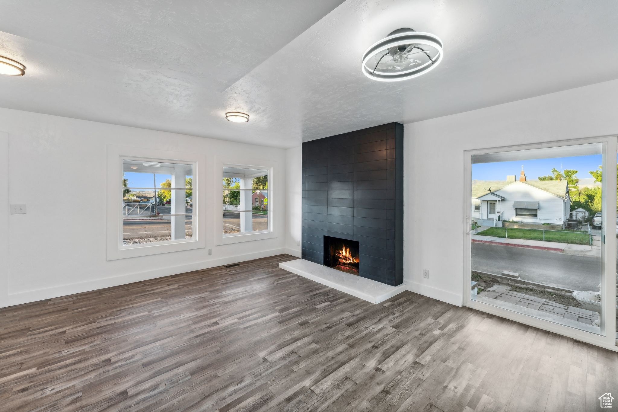 Unfurnished living room featuring hardwood / wood-style flooring, a fireplace, and a textured ceiling