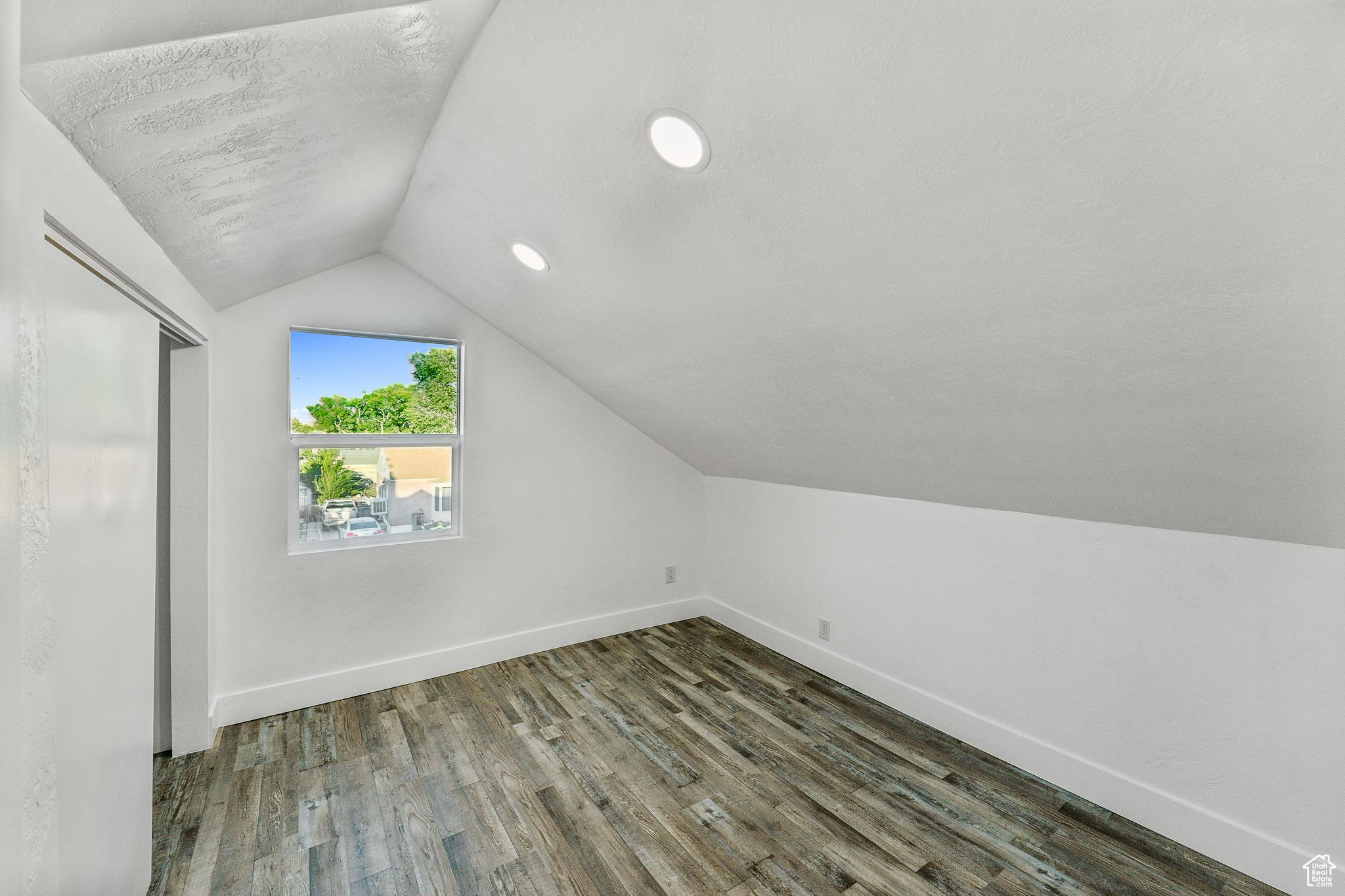 Bonus room featuring vaulted ceiling and dark wood-type flooring