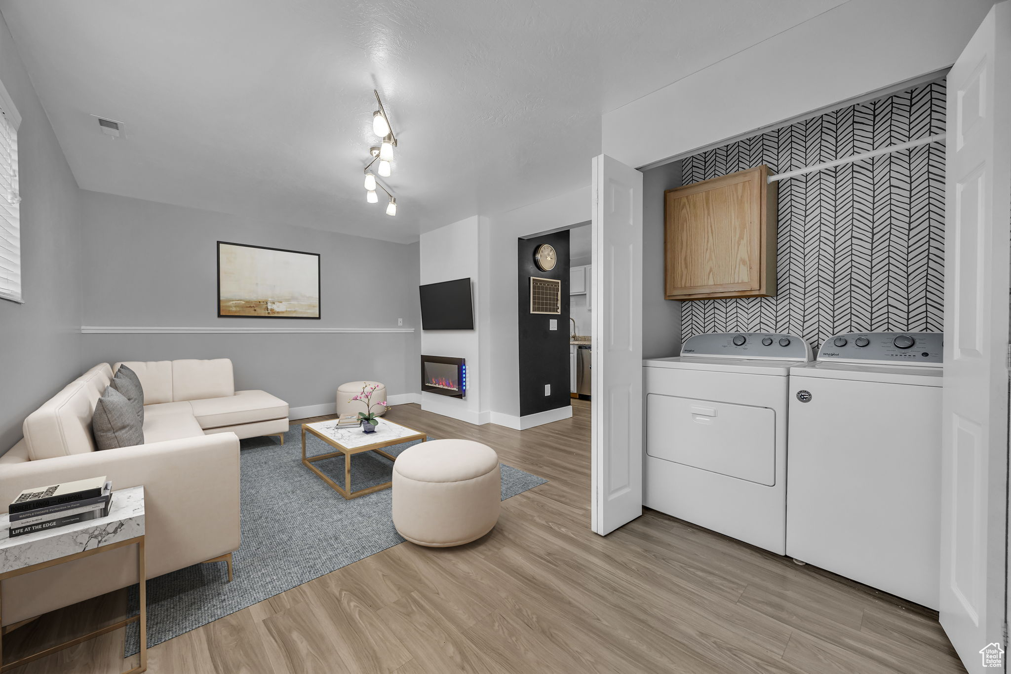 Living room with washer and dryer and light hardwood / wood-style flooring