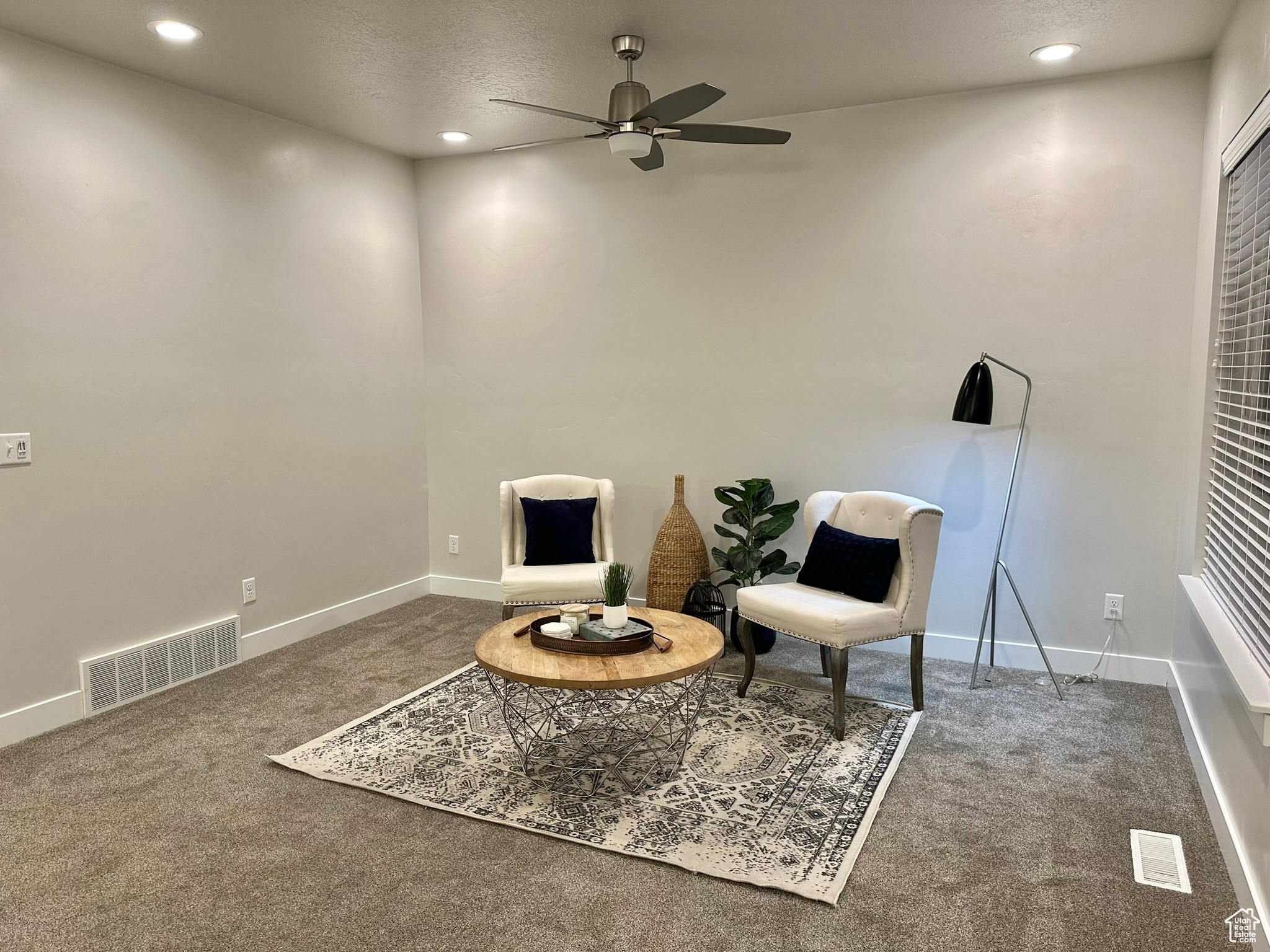 Sitting room featuring carpet, ceiling fan, and a textured ceiling