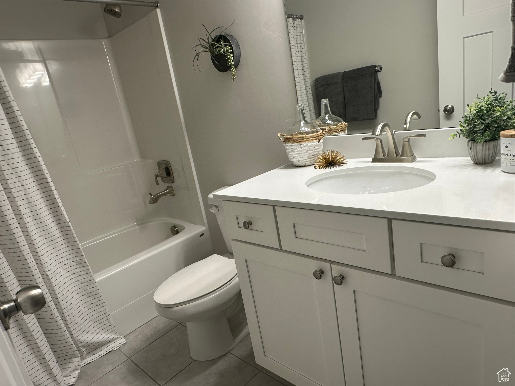 Full bathroom with shower / bath combo with shower curtain, tile patterned flooring, vanity, and toilet