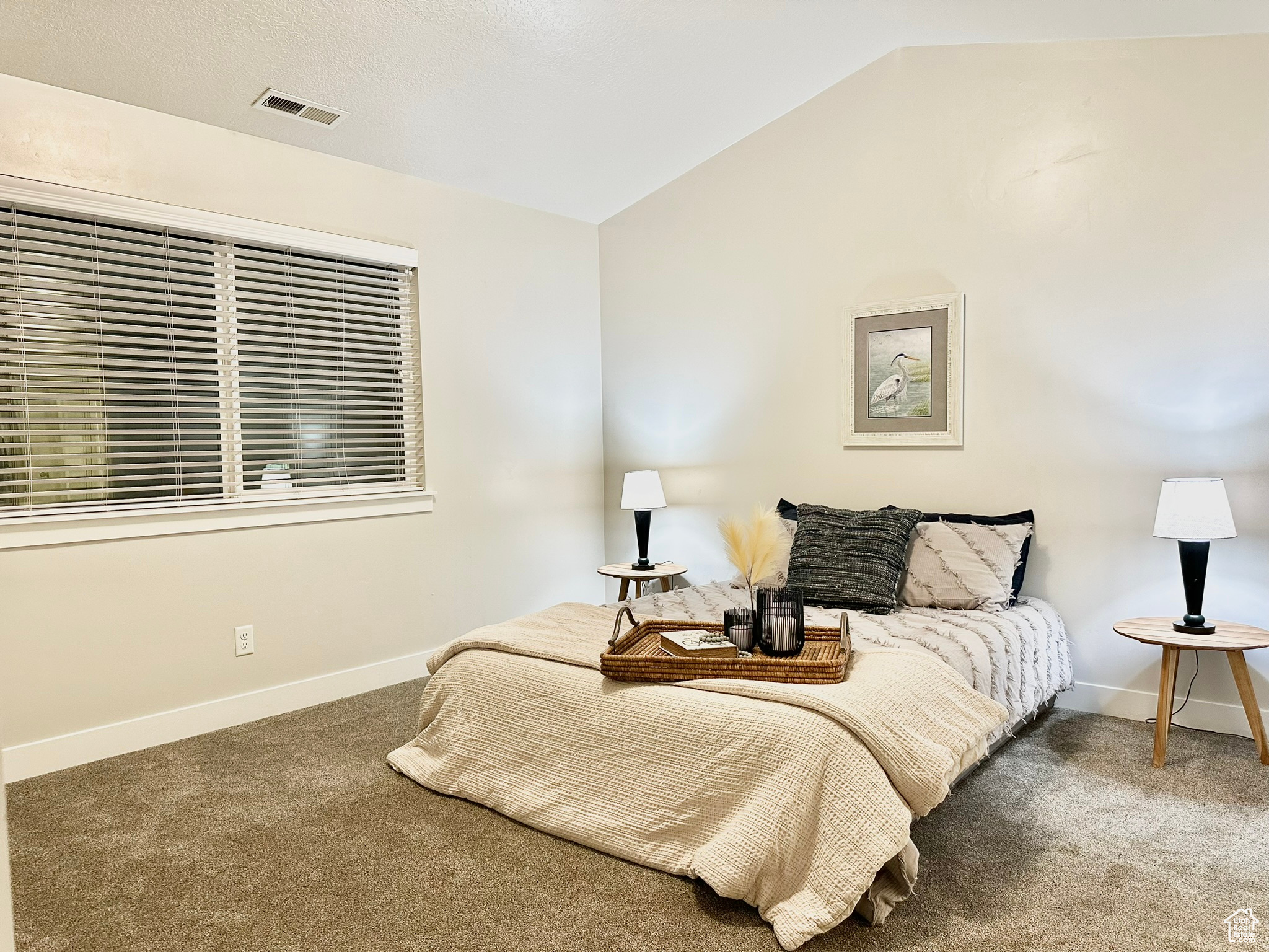 Carpeted bedroom featuring vaulted ceiling