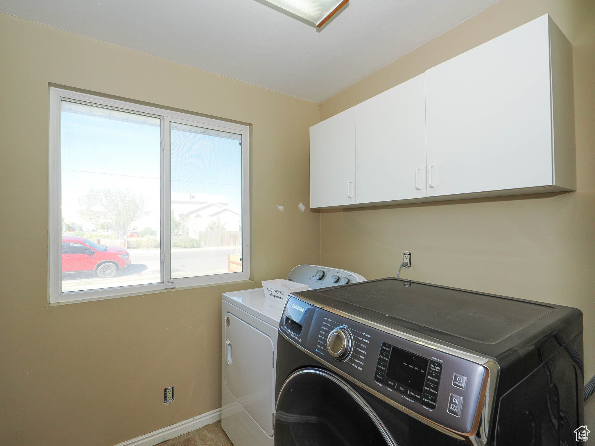 Washroom featuring washing machine and clothes dryer and cabinets