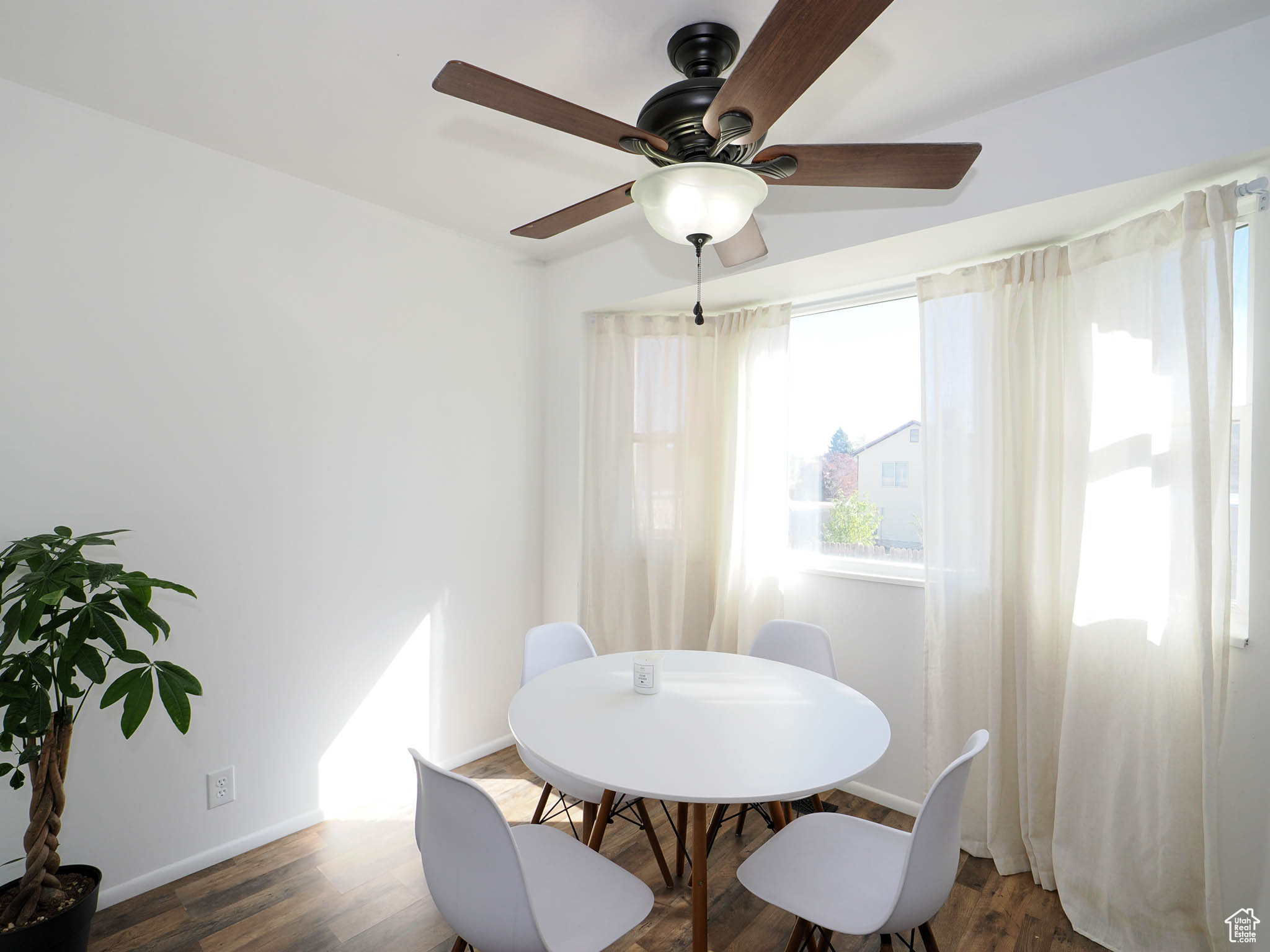 Dining space featuring ceiling fan and dark wood-type flooring