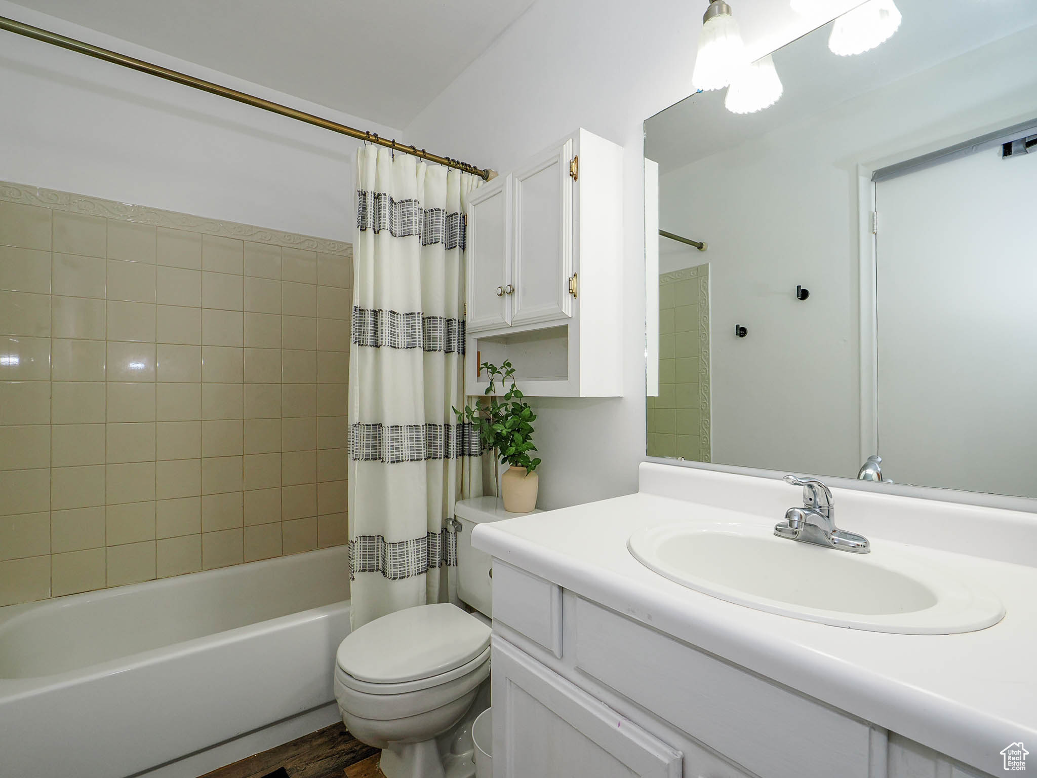 Full bathroom with shower / tub combo, hardwood / wood-style floors, vanity, and toilet